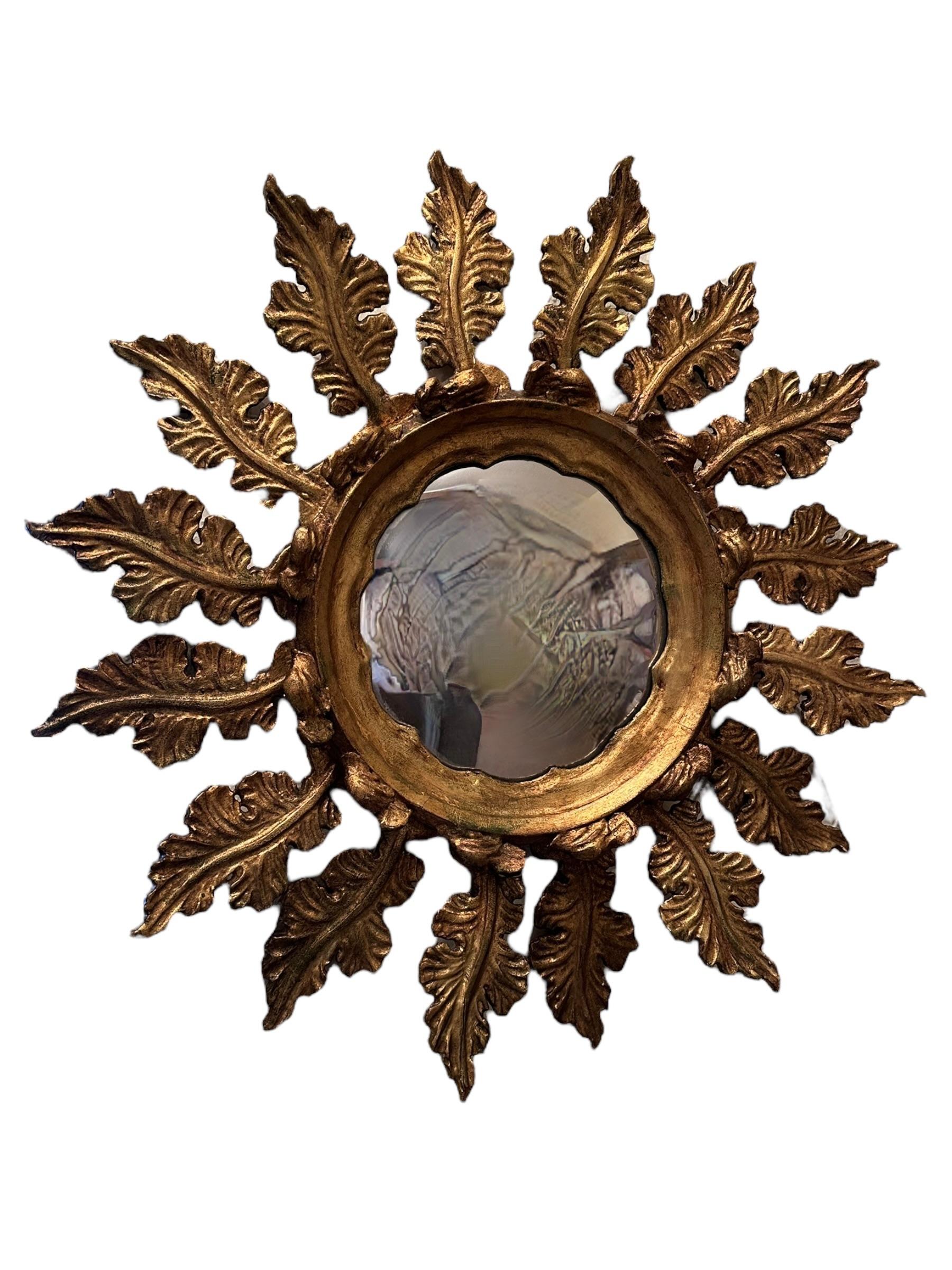 A gorgeous starburst sunburst mirror. Made of gilded wood. Stunning exceptional Leaf design. It measures approximate: 26.5