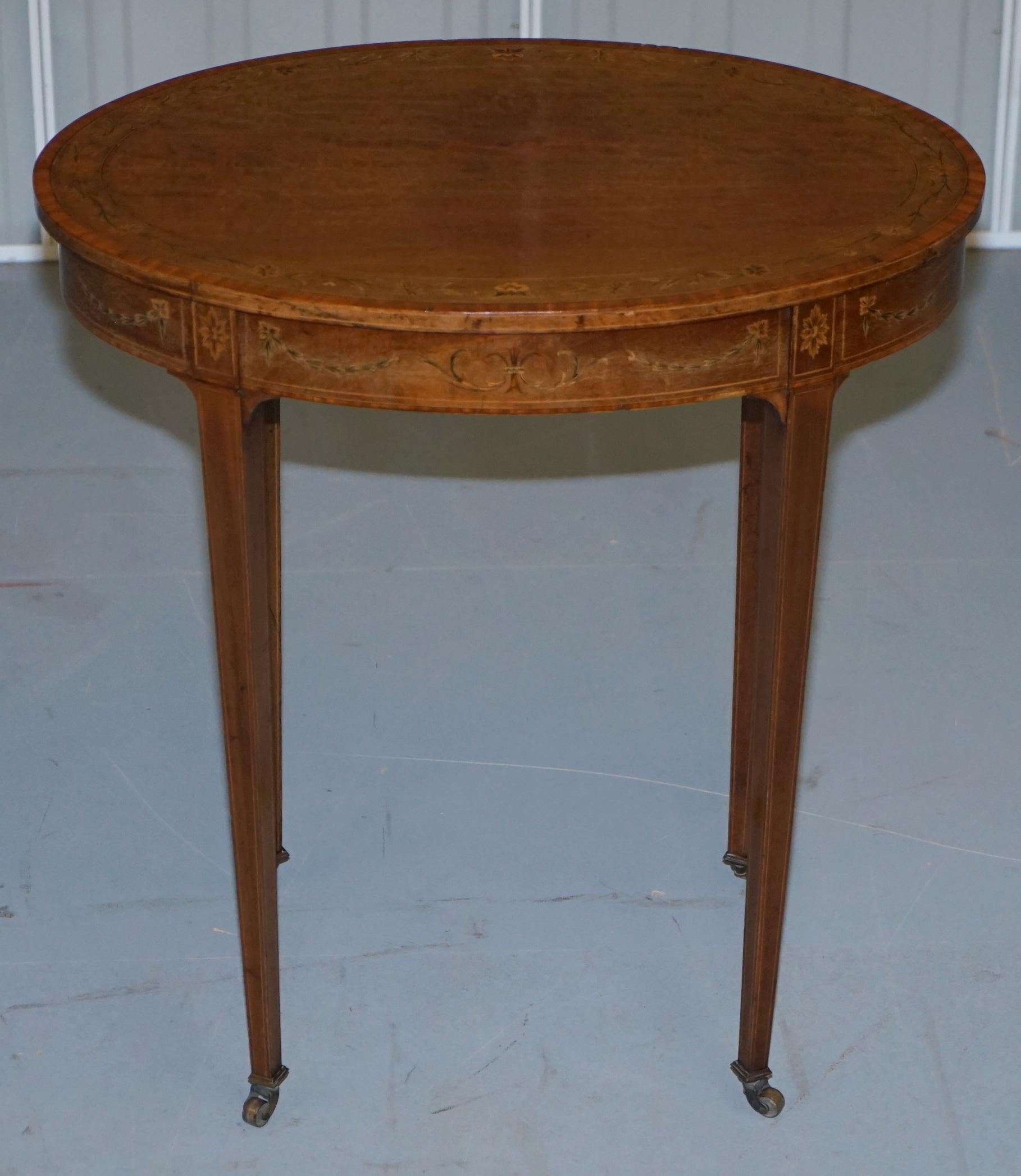 Nous sommes ravis d'offrir à la vente cette table d'appoint ovale Victorienne Sheraton en noyer incrusté de fleurs

Historiquement, elle aurait été utilisée comme table d'argent ou de thé, mais vu le niveau et la qualité de l'incrustation, elle