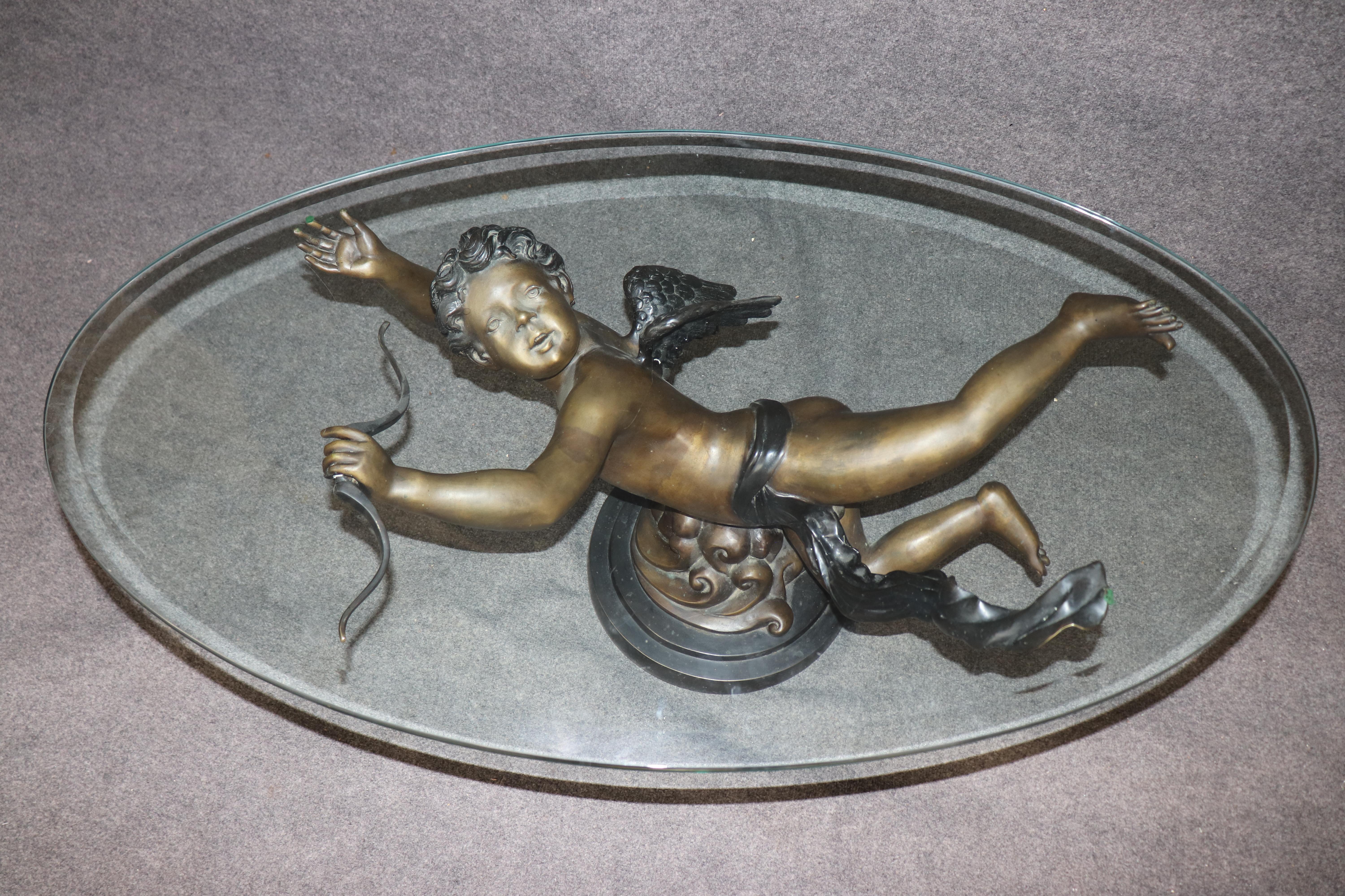 Il s'agit d'une superbe table basse en bronze massif et verre épais. La table est amagnétique et a un aspect bronze. La table est en bon état et présente un ravissant angelot ou chérubin volant. La table peut présenter de légères éraflures sur le
