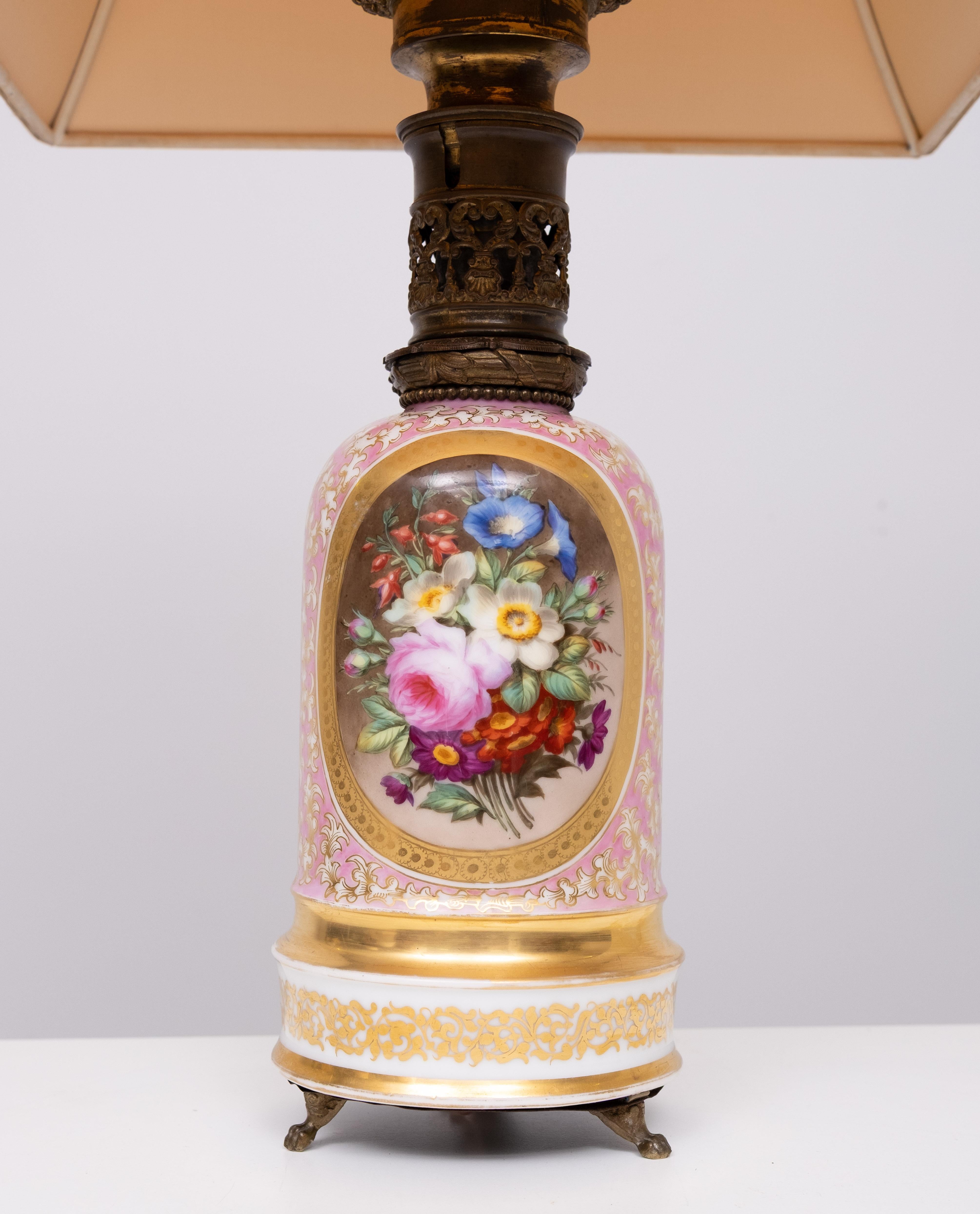 Stunning Oil lamp. conversion to table lamp. Porcelain top quality 
Hand painted Flower decor . The best i have seen in along time.                   Two hand painted Flower scenes . Gold rim decor . Pink color . 
new Pink color rewired . France