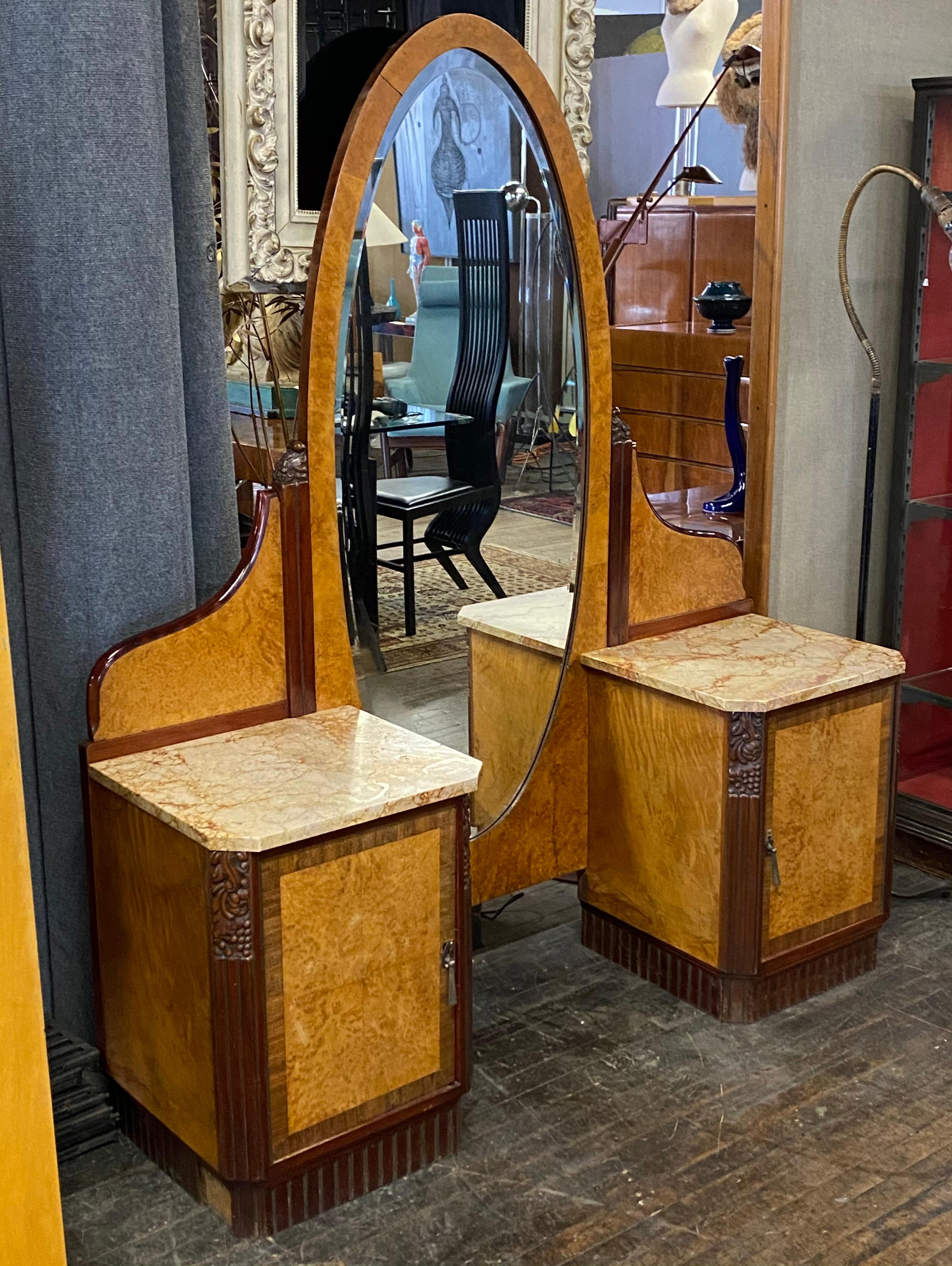 Stunning French Art Deco vanity/ dressing table/ full view oval mirror, beautiful burl and mahogany, Classic Art Deco grapevine stylized details, retains original marble tops, also one drawer (each side) behind doors, stylized brass drop pulls,