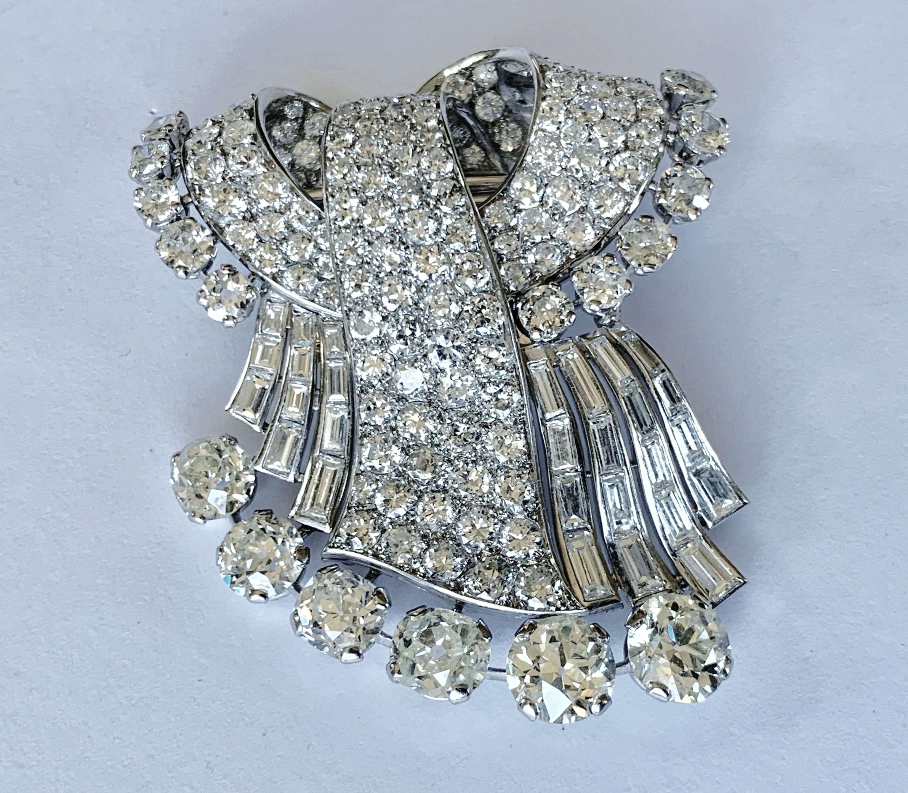 Exquisite Platinum und white gold brooch set with 6 old cut diamonds of approximately 9.00 ct, 28 Diamond baguettes of ca. 5.00 ct, 11 old european cut Diamonds of ca. 3.00 ct, and 129 pave set diamonds of ca. 10.00 ct. 
Dimensions ca. 5,8 x 4,9 cm.