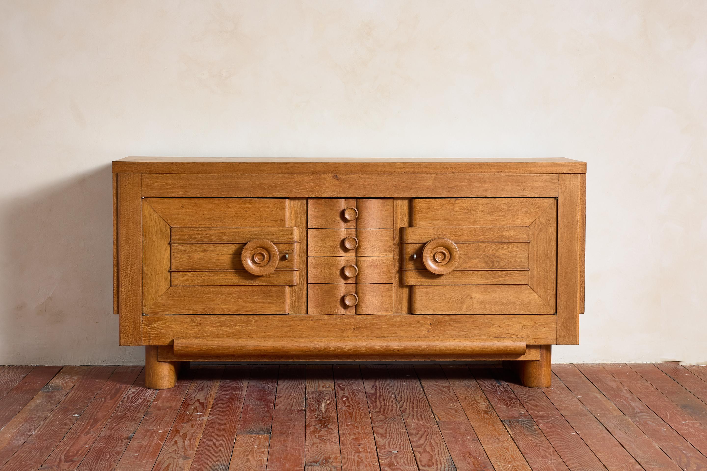 Unique French Oak sideboard cabinet -1940's 

Large bulbous shaped knobs open the cabinet doors open to reveal large amount of shelving and center drawers 

Intricate wood detailing with original hardware

Wonderful original warm wood patina.