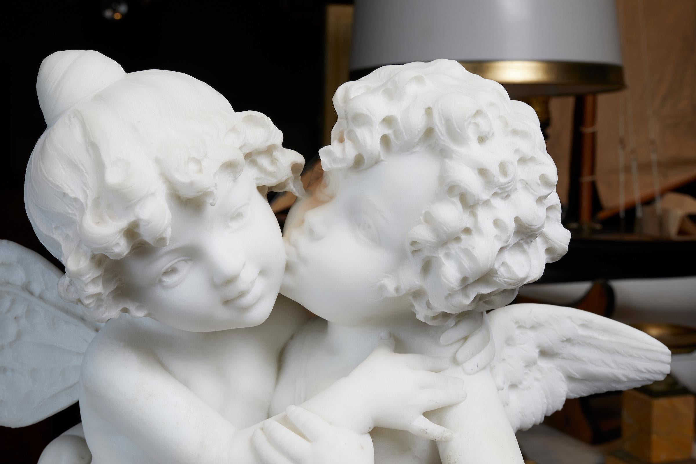 Stunning French white statuary marble of a young couple of cherubs resting on a polished marble base.