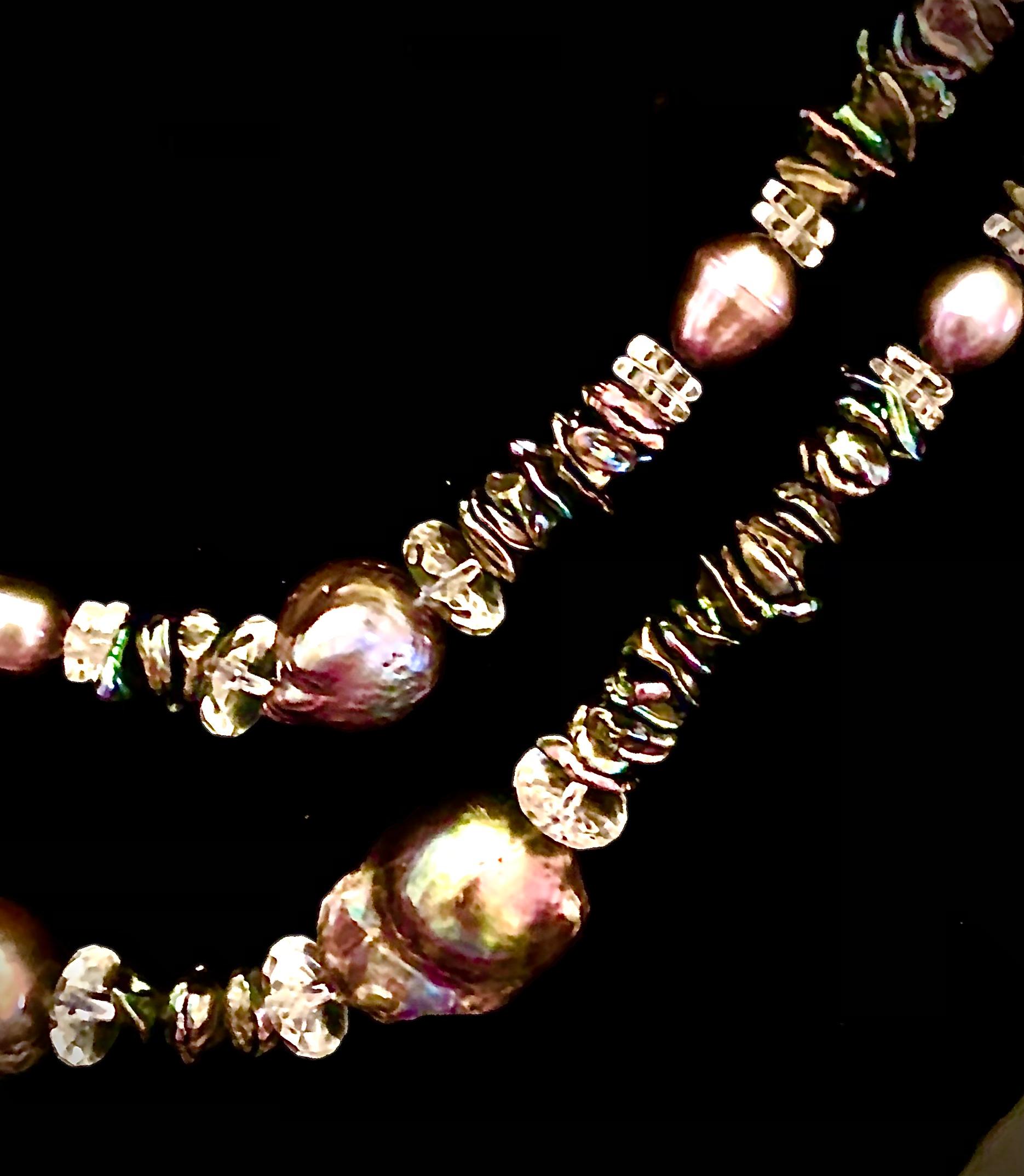 Stunning and unique double necklace. Longer composed of peacock baroque pearls measuring from approximately 22mm to over 25mm. These pearls have intense green, mauve and purple overtones. The large pearls are flanked with 10mm rock crystal faceted