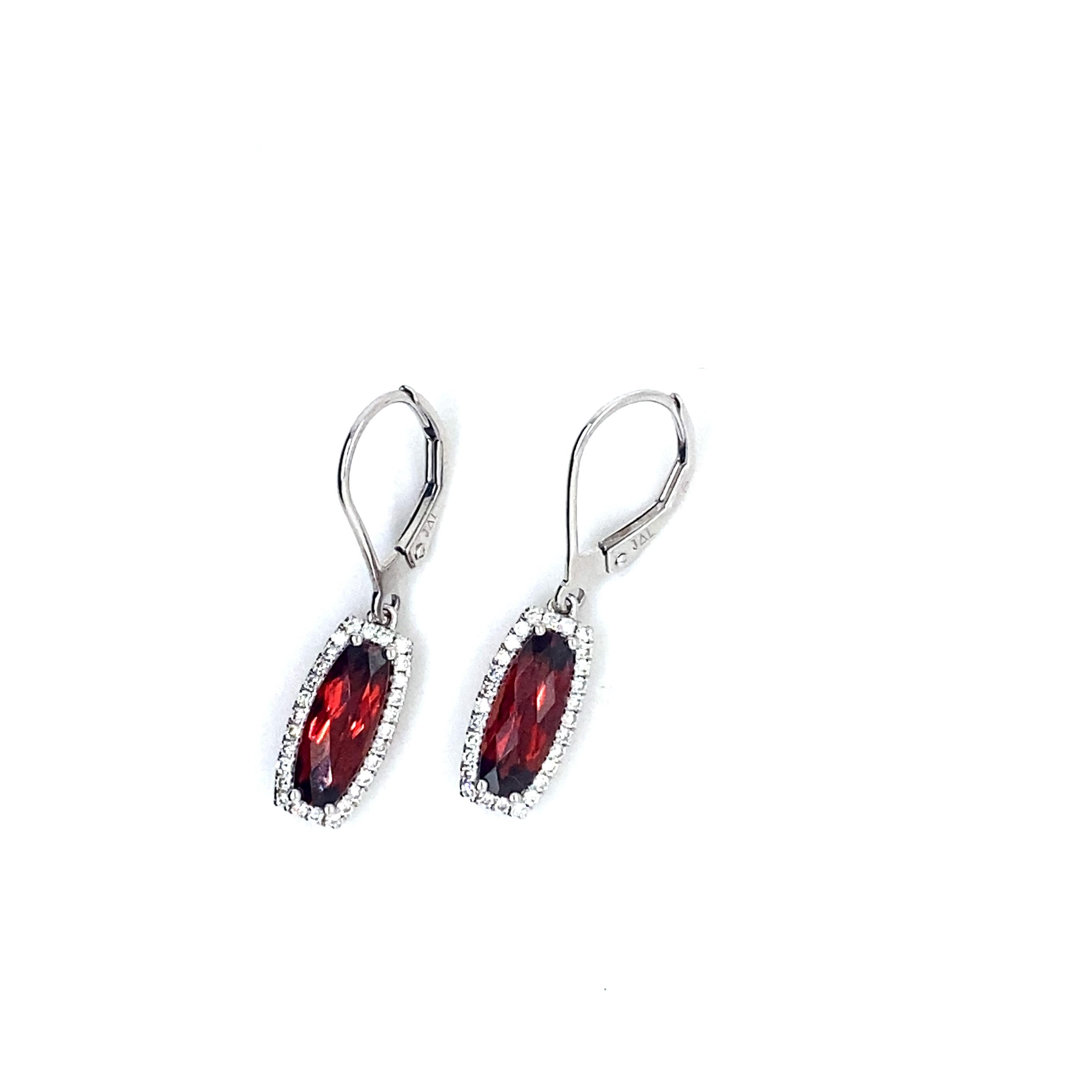 These unique dangle garnet and diamond earrings will look stunning on any earlobe! There are two checkerboard cushion cut garnets that have an elongated shape and the diamonds that are around are round brilliant cut set in very secure four prong