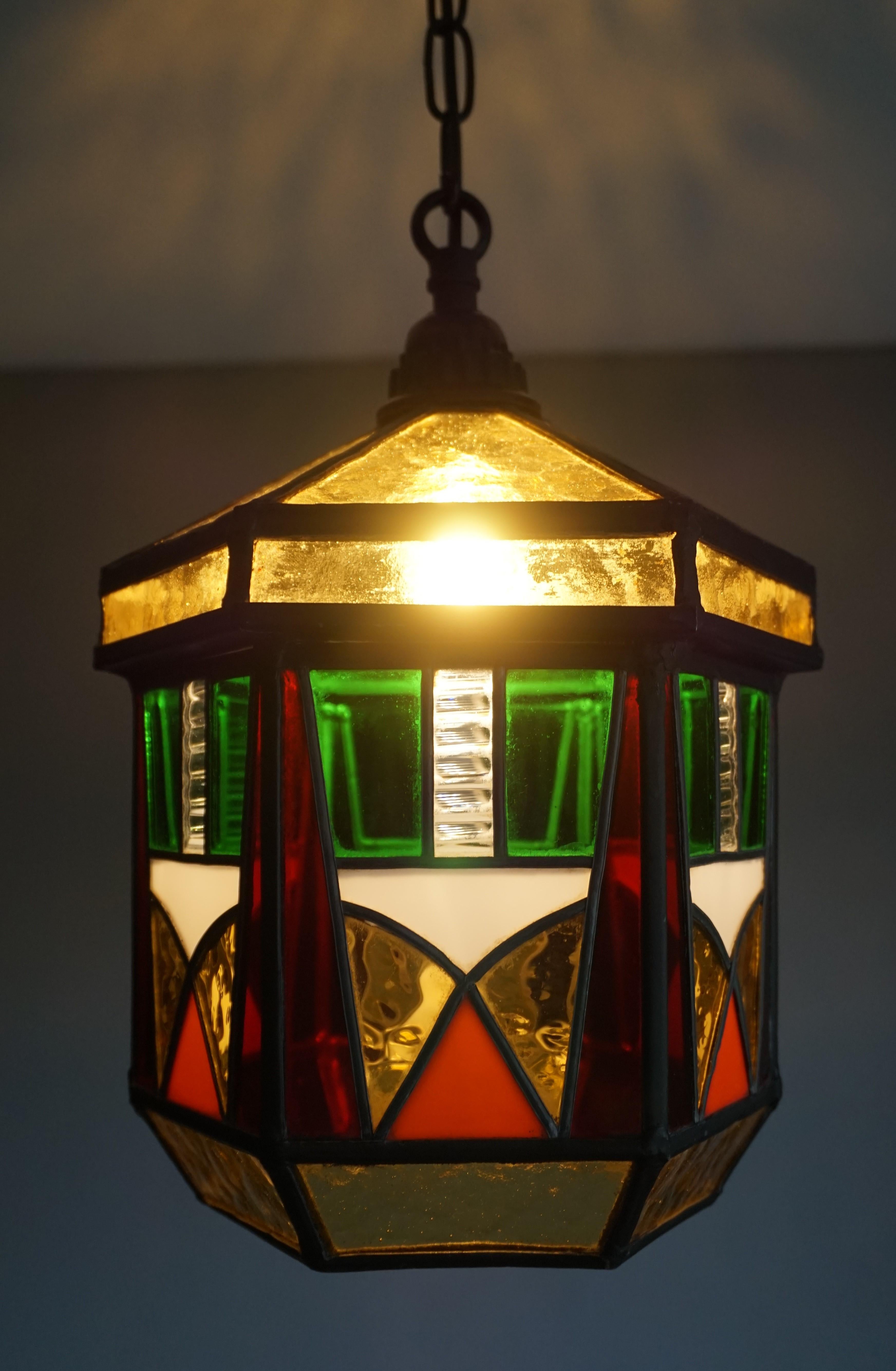 Striking stained glass Art Deco ceiling light.

This hexagonal Art Deco fixture from the 1920s is the perfect lighting solution for an entry hall or landing. This handcrafted pendant with its straight lined patterns and wonderful warm colors