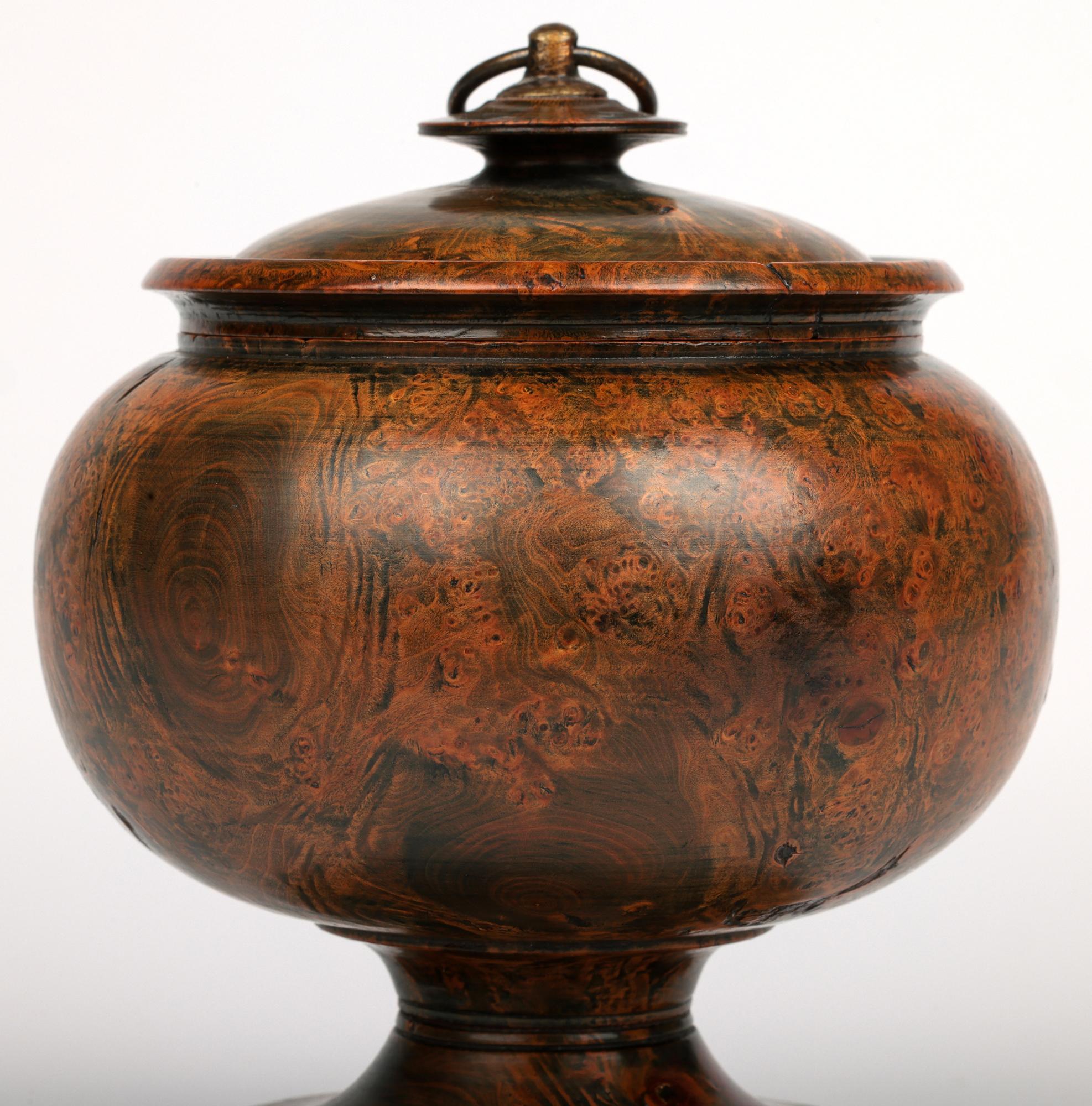 Una splendida e insolita ciotola con piedistallo in legno di radica georgiano tornito e coperchio risalente agli inizi del XIX secolo. Il contenitore in legno duro tornito è ricavato da un unico pezzo di legno e ha una forma arrotondata che poggia
