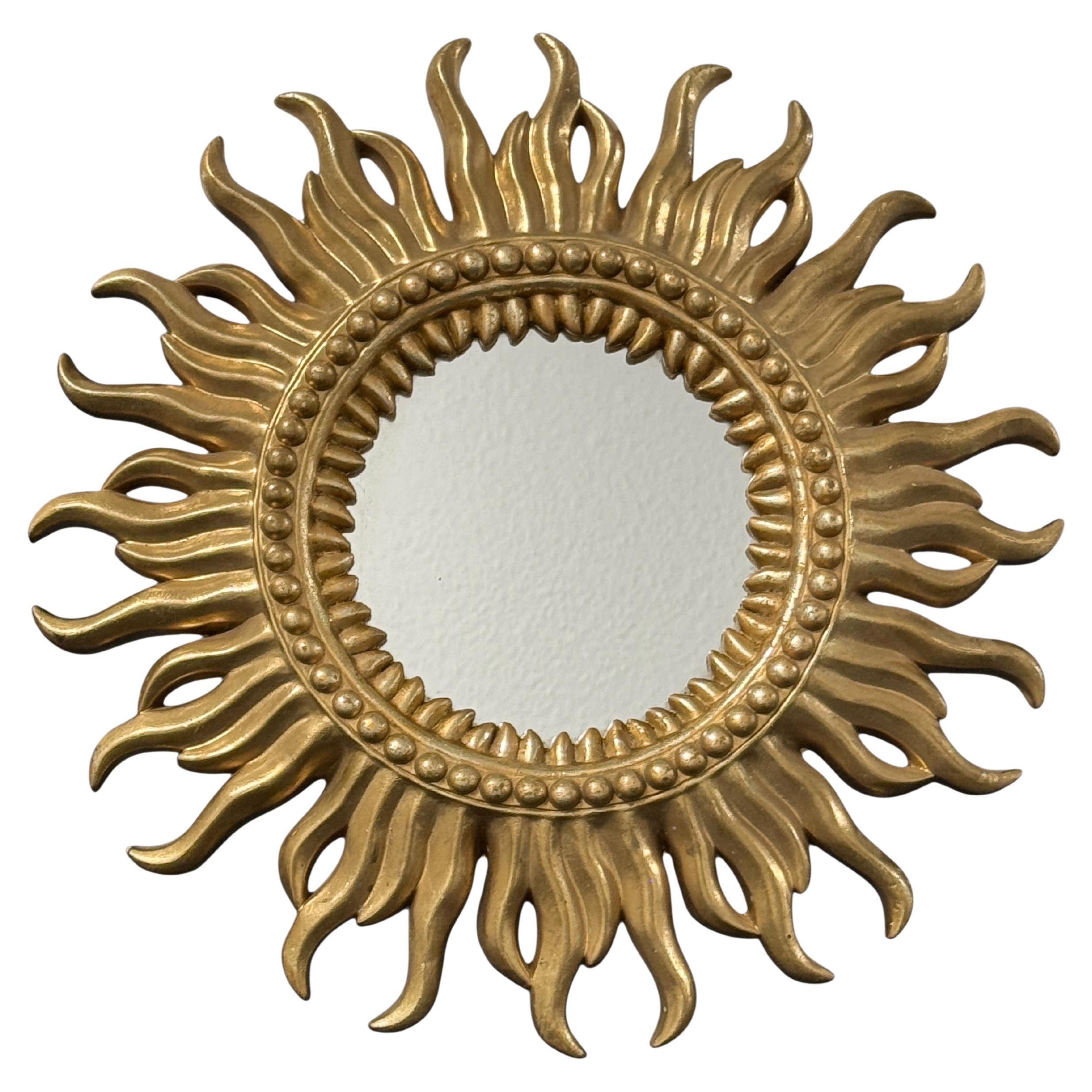 A gorgeous petite starburst sunburst flat mirror. Made of gilt resin. It measures approximate 15