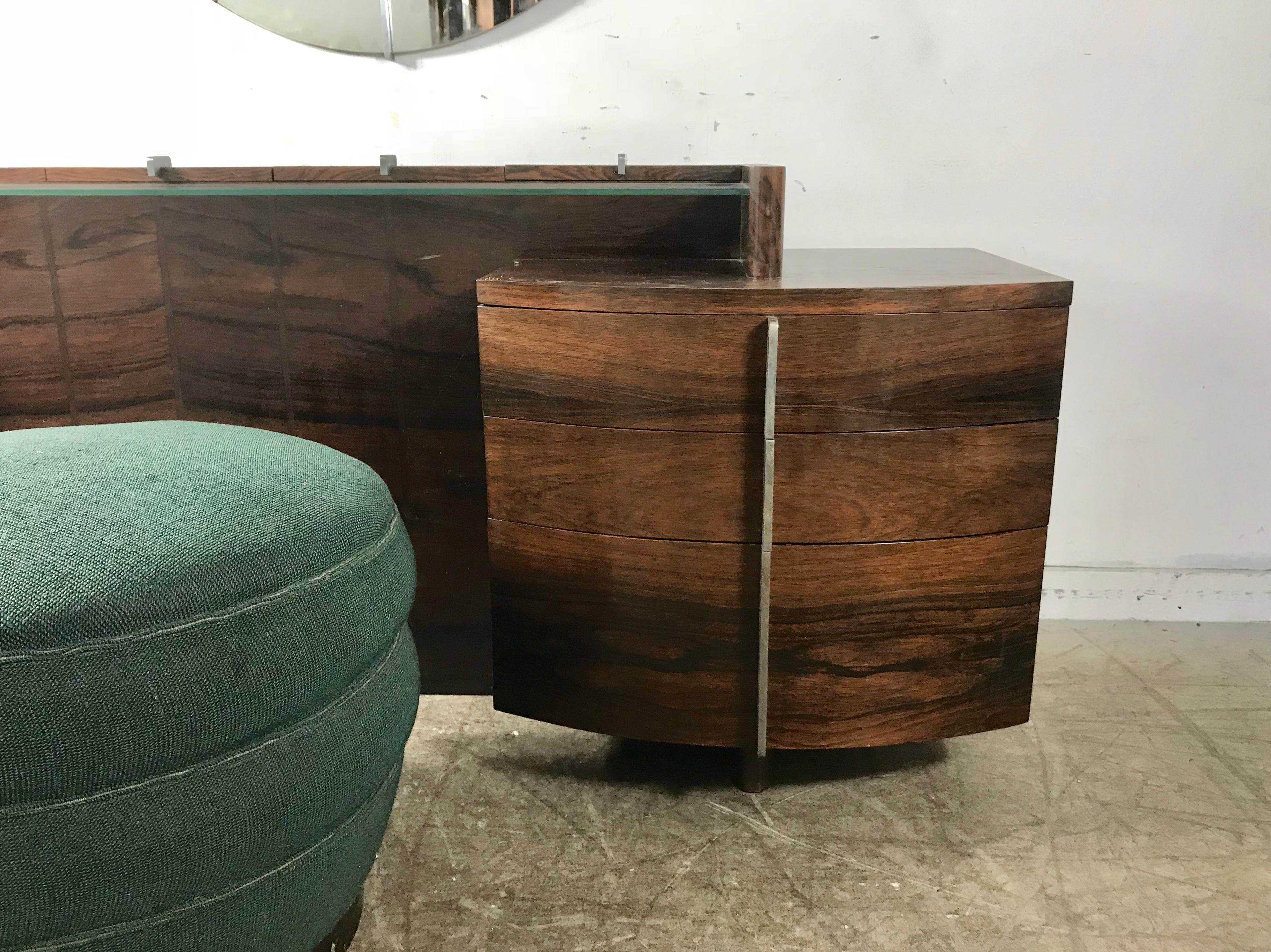 Stunning and quite rare Gilbert Rohde Art Deco rosewood dressing table, pouf and mirror, purchased recently from an amazing estate, folks originally purchased new from Herman Miller showroom in 1937..Vanity features bookmatched rosewood, with four