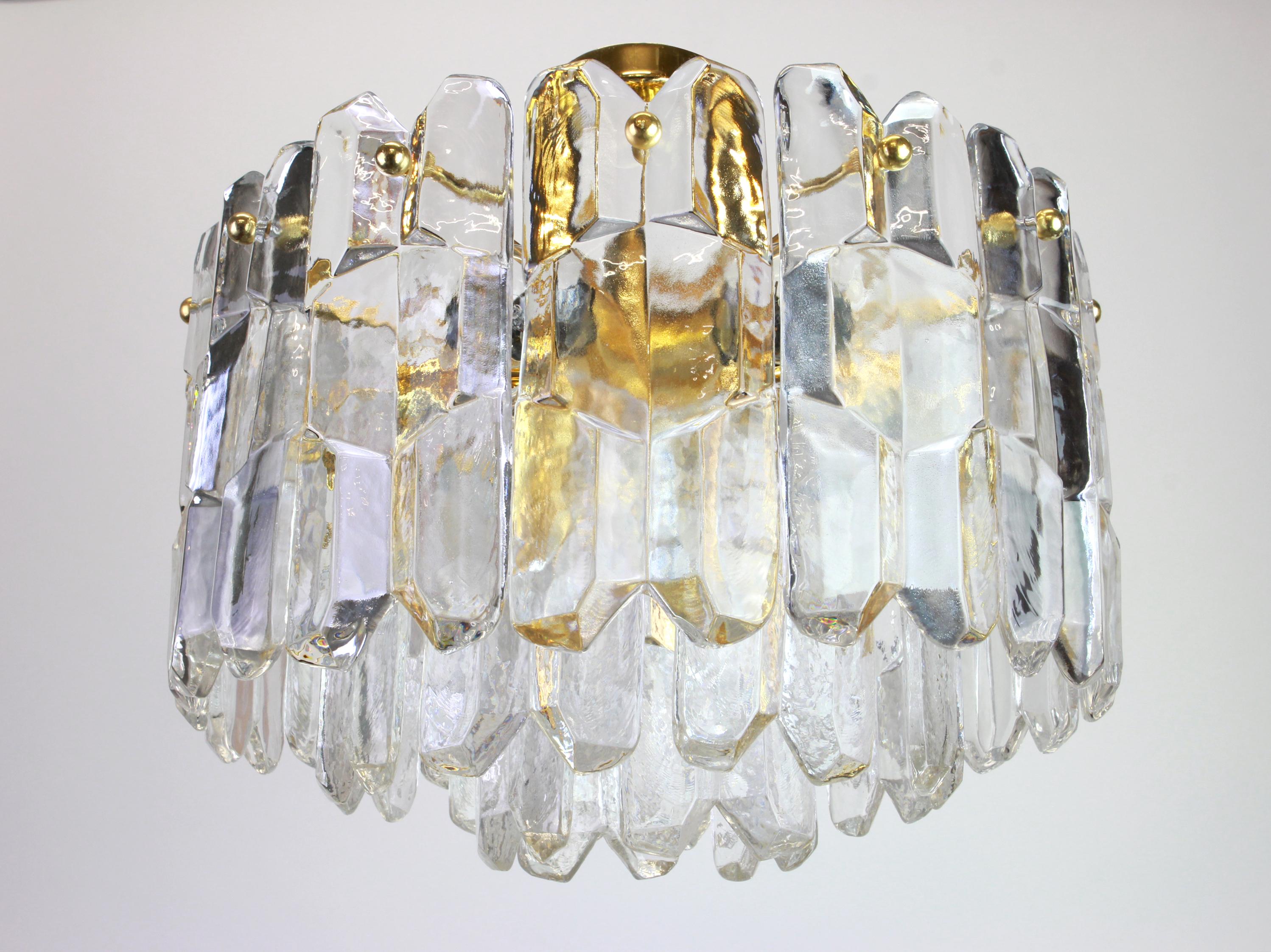 A wonderful gilt brass light fixture comprises crystal Murano glass pieces on a gilded brass frame. Its made by Kalmar (Serie: Palazzo), Austria, manufactured, circa 1970-1979.

It needs seven small bulbs and its compatible with the US / UK / ..