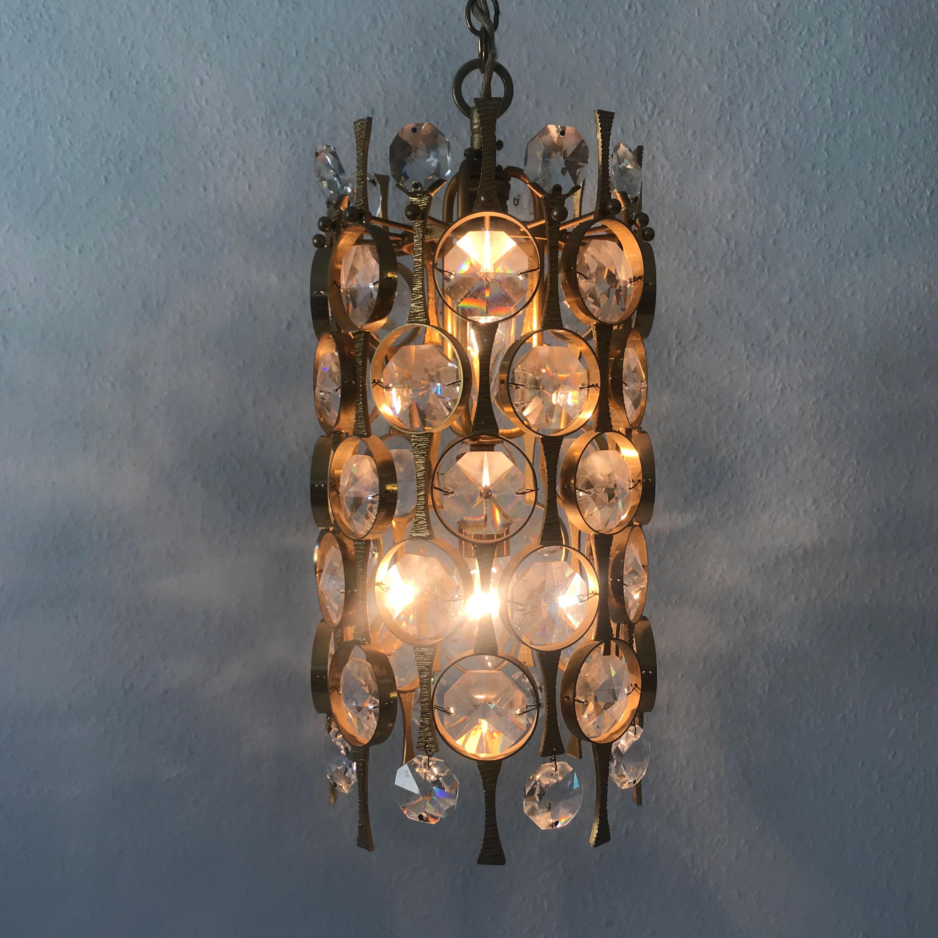 Extremely rare and elegant Mid-Century Modern chandelier or pendant lamp. Manufactured by Palwa, 1970s, Germany. Executed in gilt brass, facet cut crystal glass.

The lamp needs two E14 Edison screw fit bulbs. It is wired and in working condition.