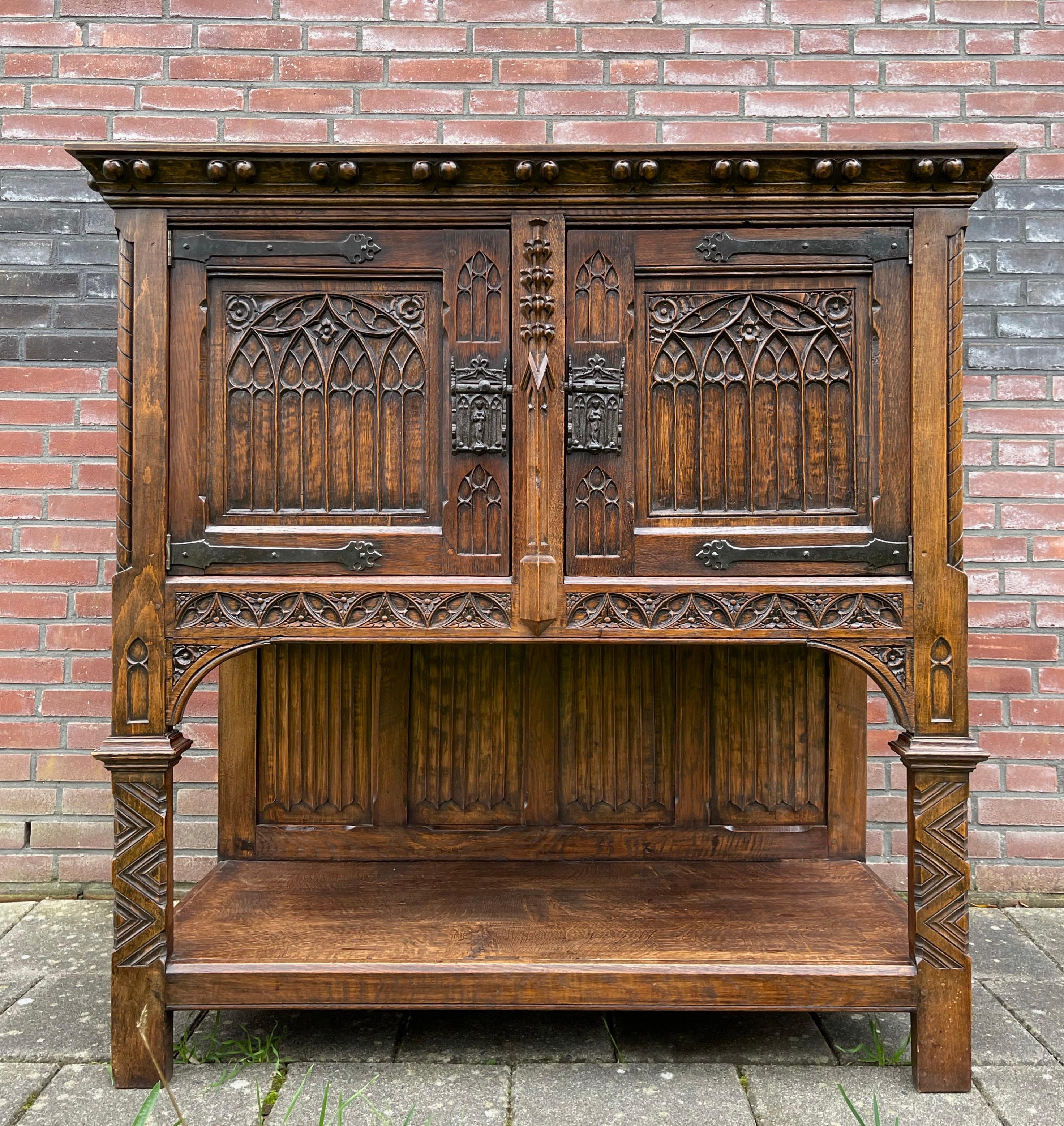 Tiger oak Gothic cabinet standing high on its feet.

This beautifully and deeply carved tiger oak cabinet from the early 1900s is in excellent condition. It comes with top quality, hand carved details and the warmest ever patina. This handcrafted