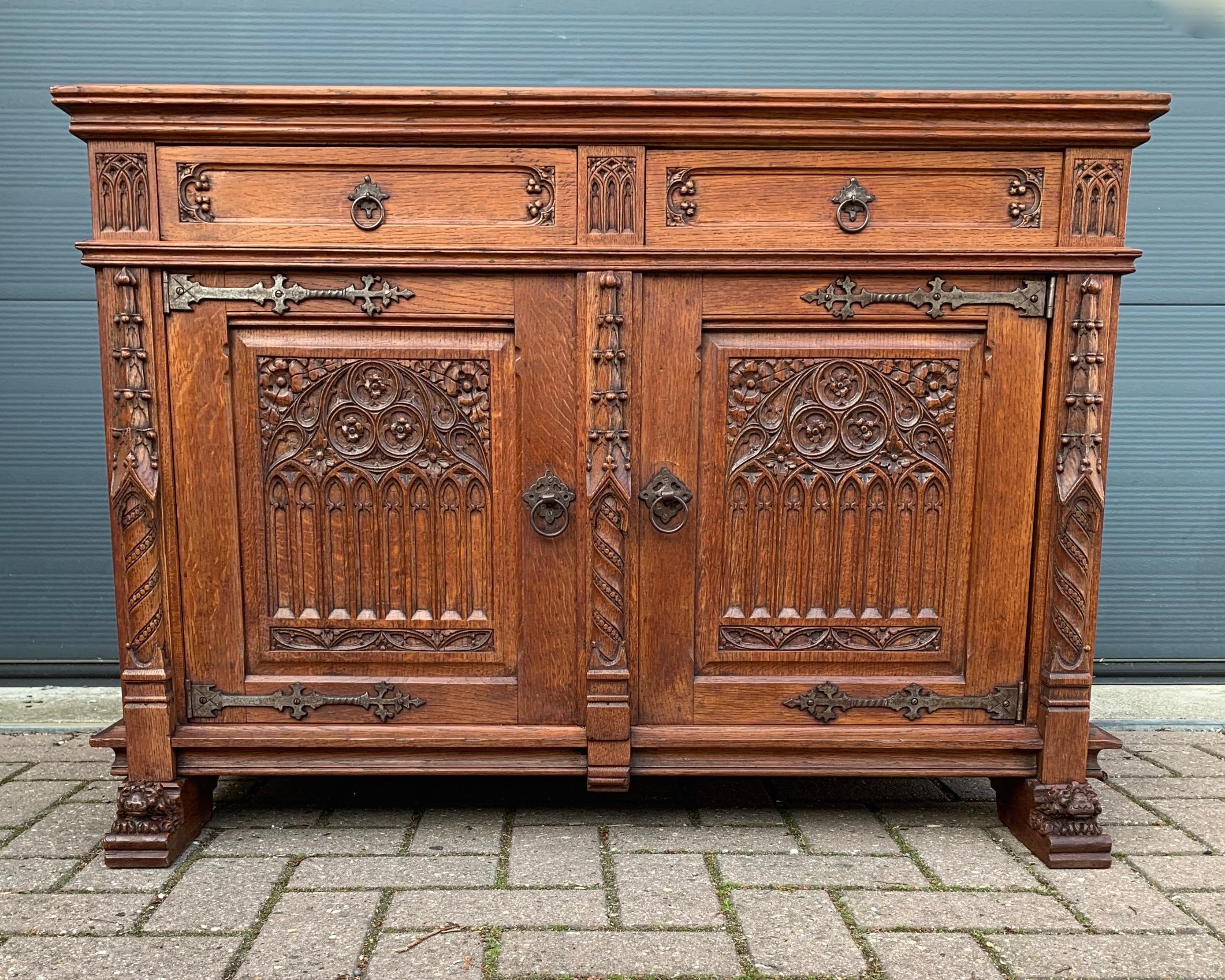 Early 20th century, solid tiger oak Gothic cabinet with lion sculptures on its feet.

This beautifully and deeply carved tiger oak cabinet from the early 1900s is in excellent condition. It comes with top quality, hand carved details and the warmest