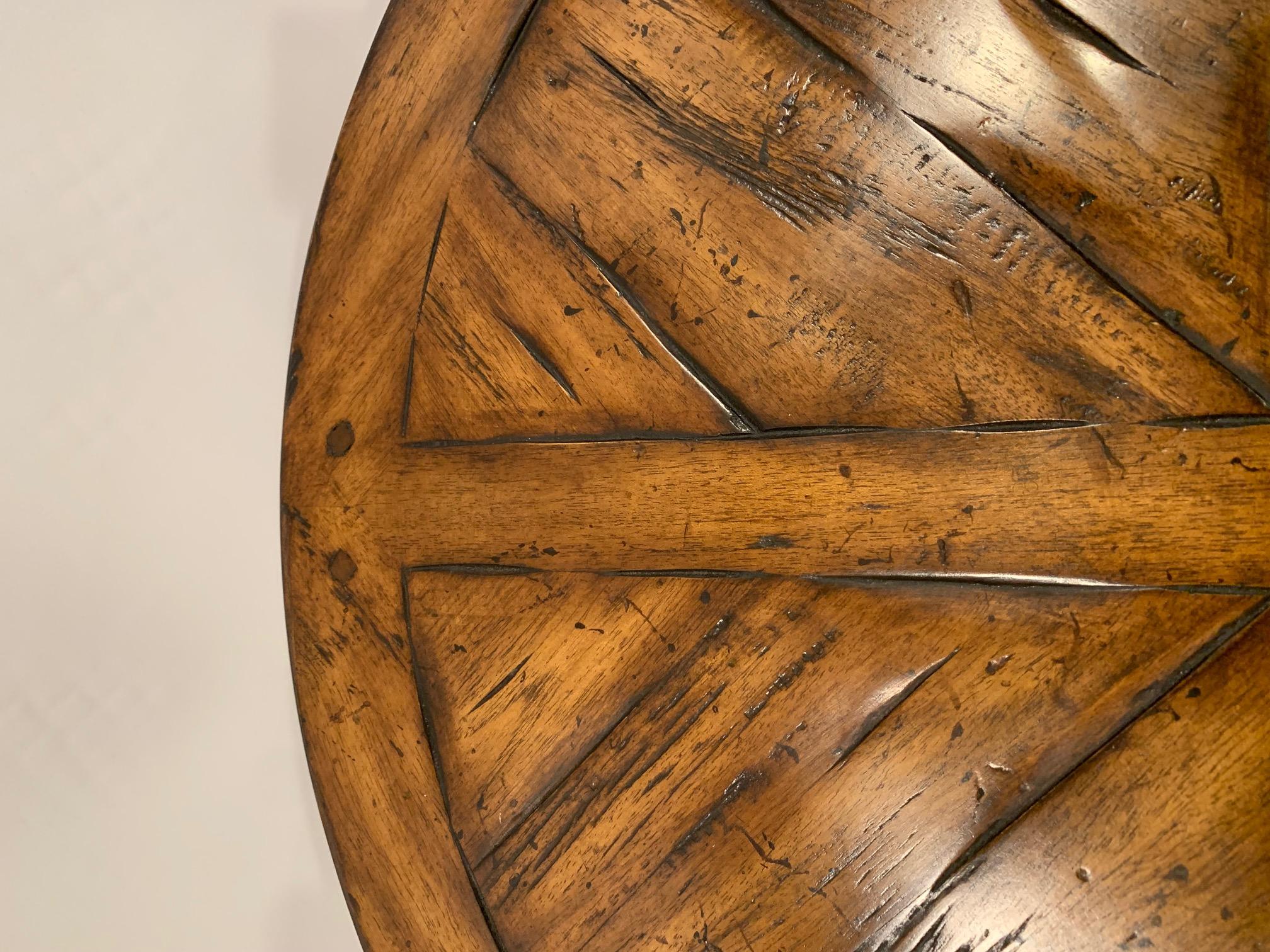 Masculine round hardwood side table having handsome inlaid pattern on top, single drawer, and X stretcher between four legs.