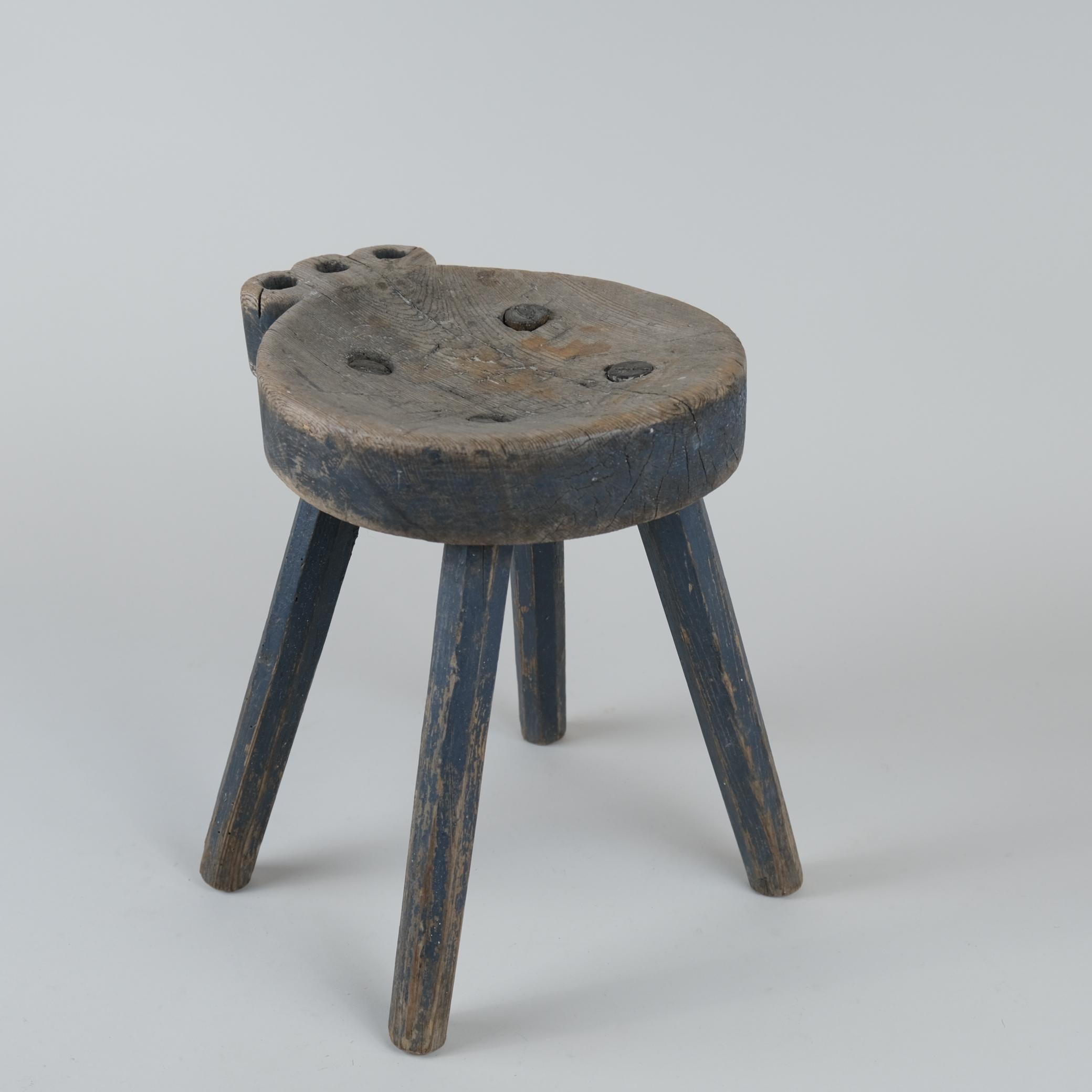Magnifique tabouret folklorique finlandais sculpté à la main datant de la fin des années 1800. Le tabouret conserve la couleur bleue d'origine, couramment utilisée pour les meubles de l'époque. Le tabouret semble avoir été peint en couleur moutarde