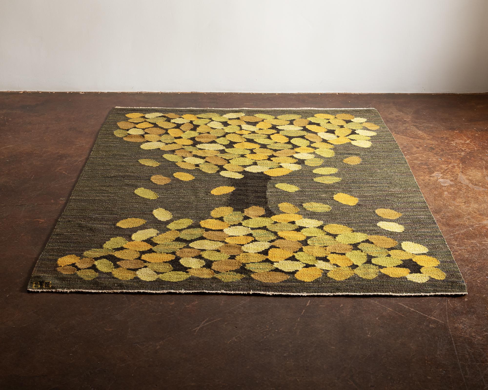 A stunning handwoven wool flatweave rug or tapestry by Brita Grahn depicting a deciduous tree in fall. Executed in vibrant shades of green, yellow and brown on a greenish grey background. Signed BG, Sweden, 1960s.

Brita Grahn, Swedish textile