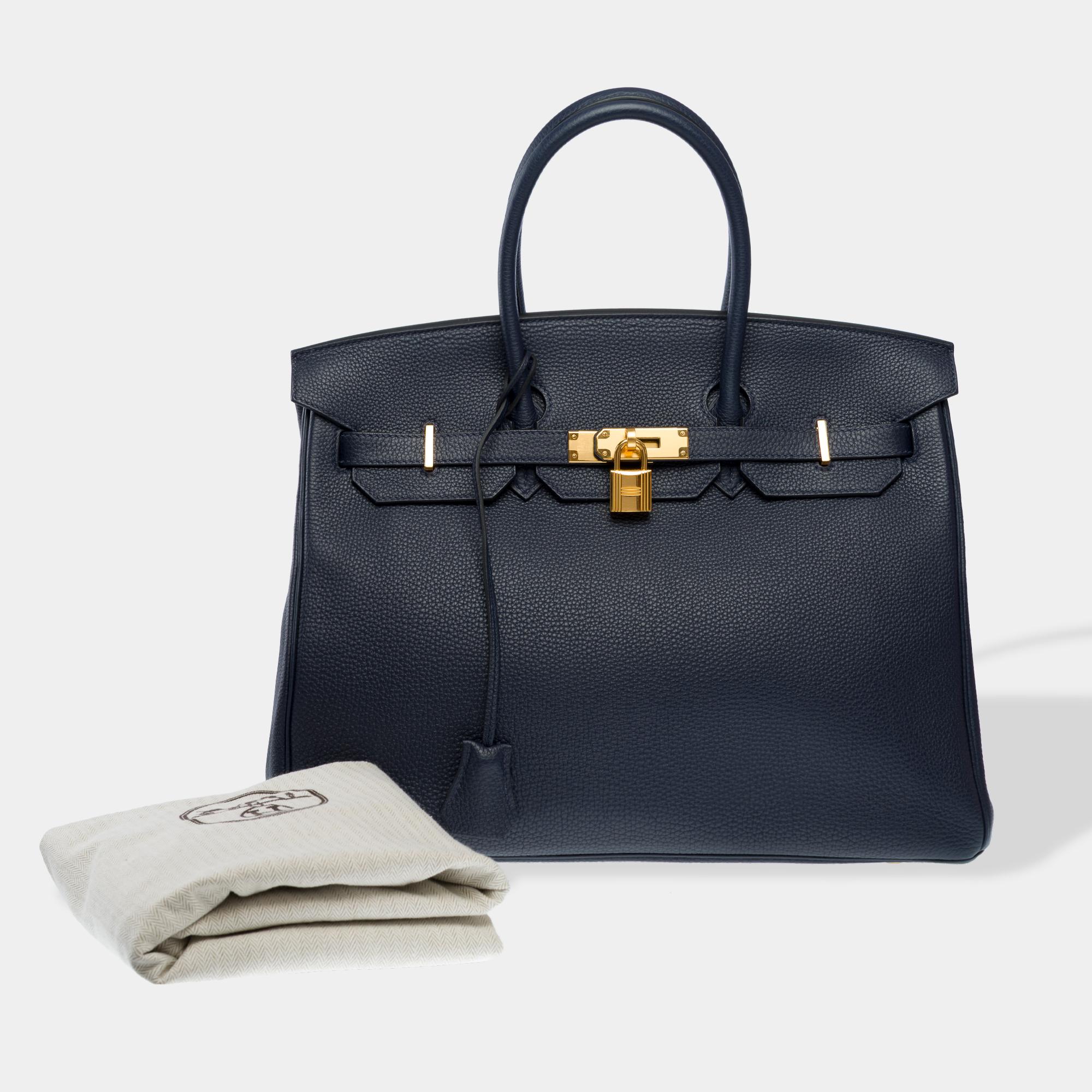 Sublime​ ​Hermes​ ​Birkin​ ​35​ ​handbag​ ​in​ ​Bleu​ ​nuit​ ​Togo​ ​calfskin​ ​leather,​ ​gold​ ​metal​ ​trim,​ ​double​ ​blue​ ​leather​ ​handle​ ​hand​ ​carry

Flap​ ​closure
Blue​ ​leather​ ​interior​ ​lining,​ ​one​ ​Zipped​ ​pocket,​ ​one​