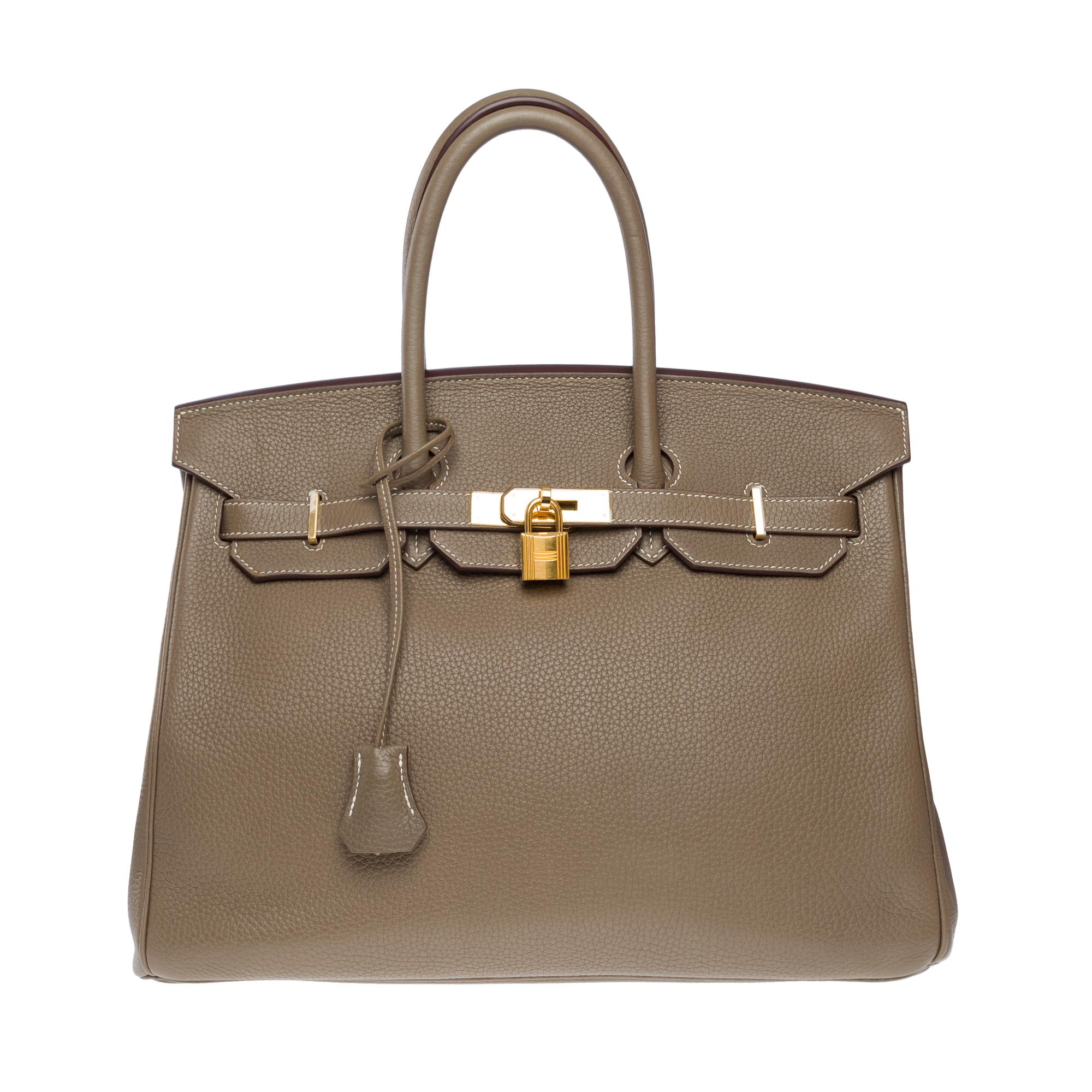 Beautiful​ ​Hermes​ ​Birkin​ ​35​ ​handbag​ ​in​ ​Etoupe​ ​Togo​ ​leather​ ​with​ ​white​ ​stitching,​ ​gold​ ​plated​ ​metal​ ​trim,​ ​double​ ​handle​ ​in​ ​grey​ ​leather​ ​for​ ​hand​ ​carry

Flap​ ​closure
Grey​ ​leather​ ​lining,​ ​one​ ​zip​