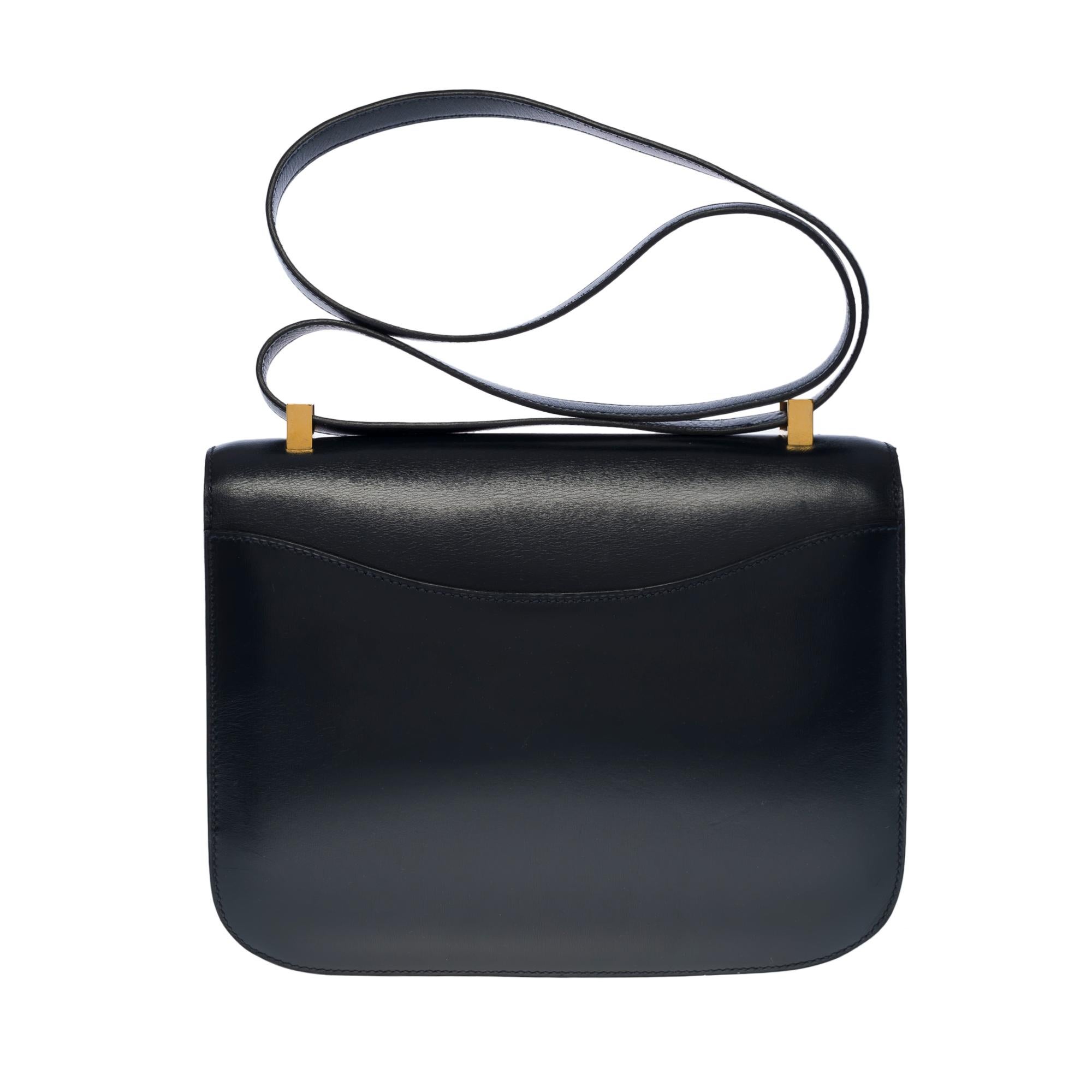 Exquisite Hermes Constance 23 shoulder bag in blue navy boxcalf leather , gold plated metal hardware, convertible handle in blue leather allowing a hand or shoulder support

Closure marked H on flap
A patch pocket on the back of the bag
Navy blue