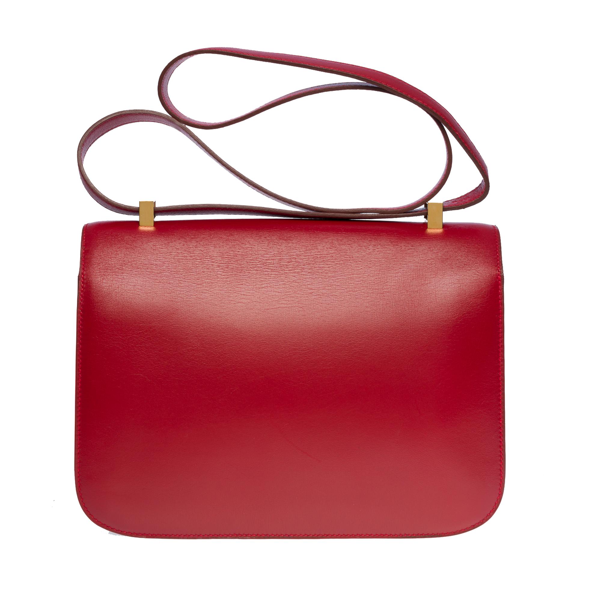 Exquisite Hermes Constance 23 shoulder bag in Red H (burgundy) boxcalf leather , gold plated metal hardware, convertible handle in burgundy leather allowing a hand or shoulder support

Closure marked H on flap
A patch pocket on the back of the