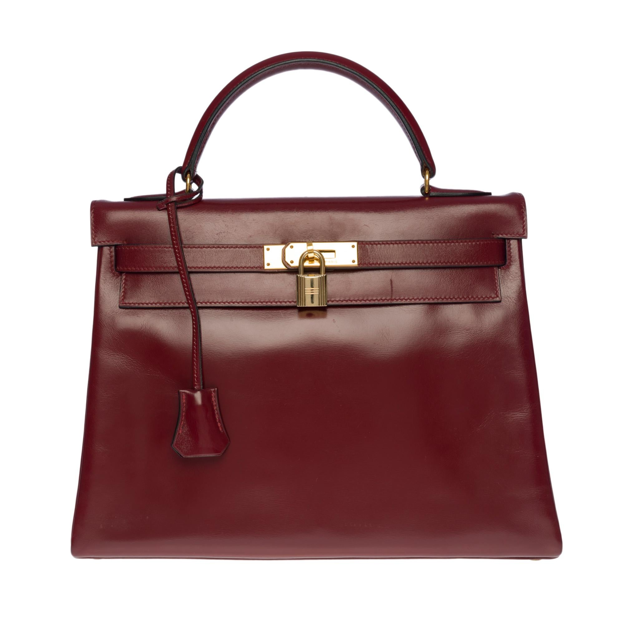 Beautiful Hermès Kelly 32 retourné handbag in burgundy leather (Rouge H), gold plated metal hardware, burgundy leather box handle allowing a hand or shoulder support
 
Flap closure
Inner lining in burgundy leather
A zippered pocket
Double patch