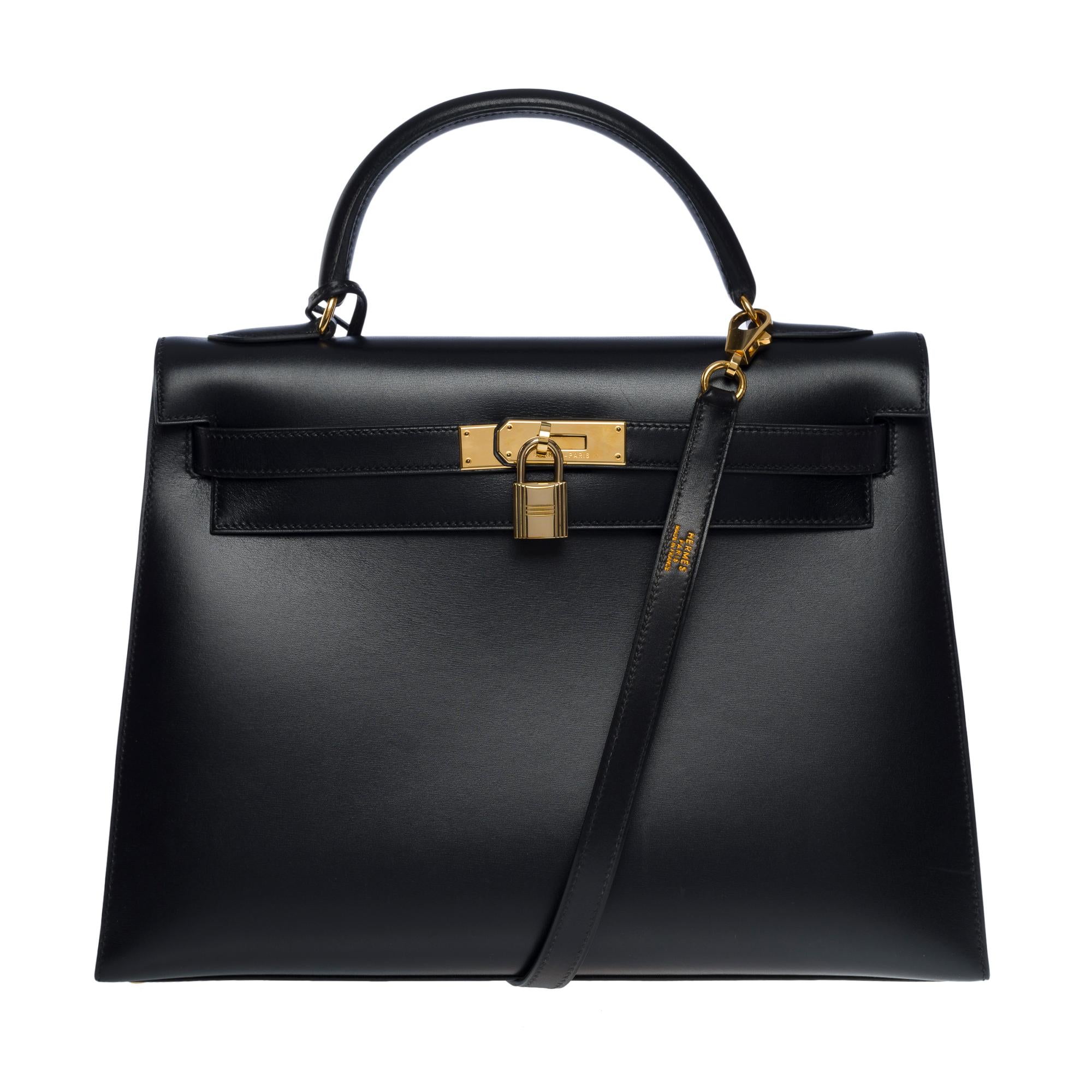 Stunning Hermes Kelly 32 sellier handbag strap in black box calf leather, gold plated metal hardware, simple black box leather handle , a removable black box leather shoulder strap for a hand, shoulder or shoulder carry

Flap closure
Black leather