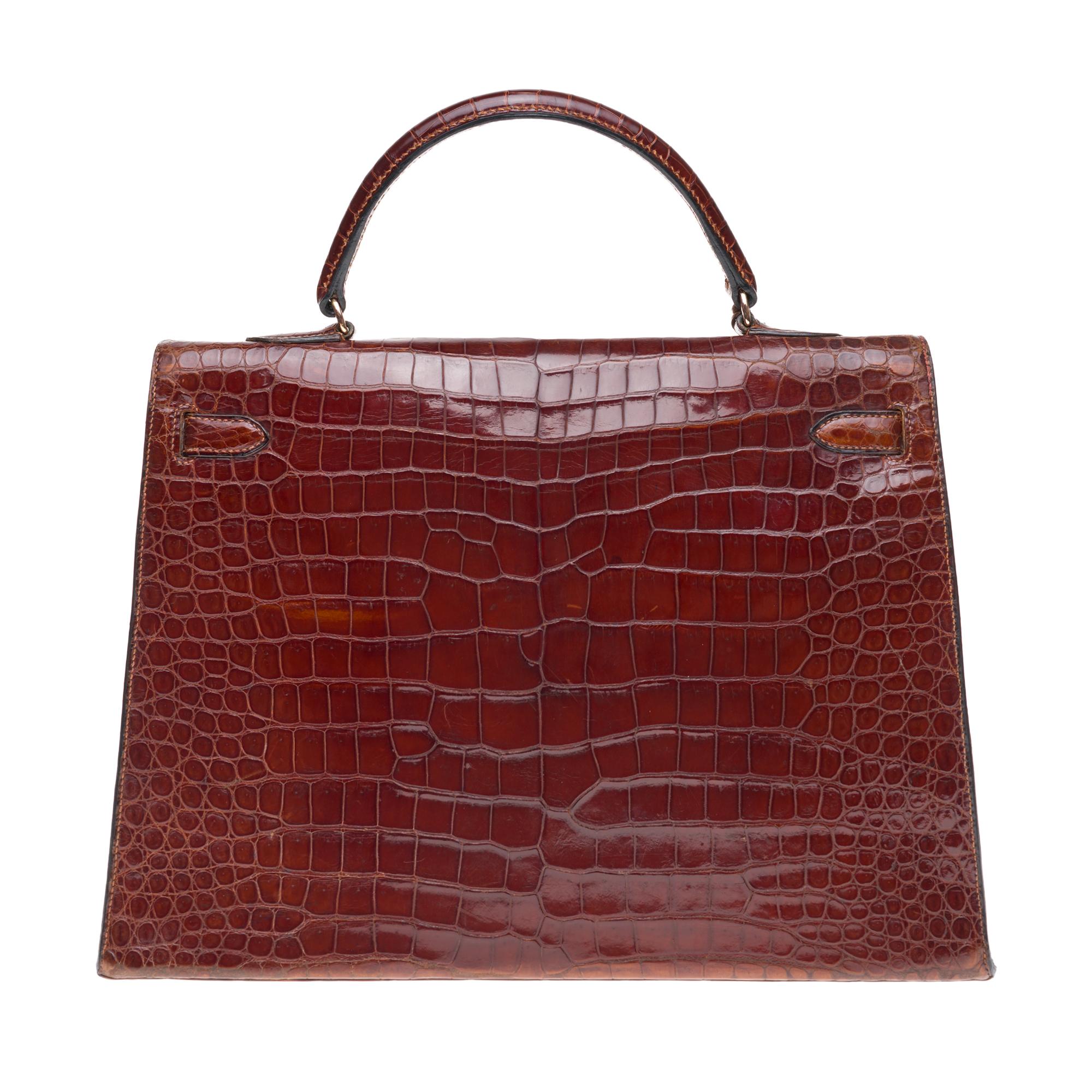 Stunning Hermes Kelly handbag 35 cm in brown Crocodile Porosus leather, gold-plated metal trim, brown crocodile handle allowing a handheld. 
Flap closure. 
Brown leather inner lining, large veneered pocket, double veneered pocket. 
Signature: