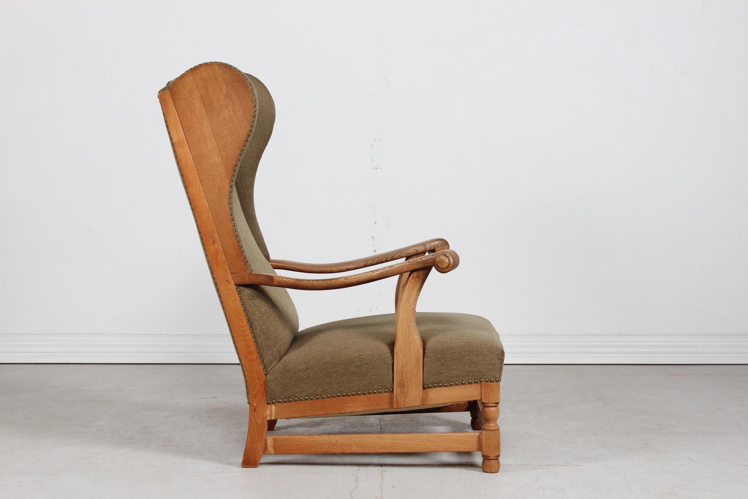 Superbe chaise à oreilles de style baroque danois à dossier haut, fabriquée à la main dans les années 1930.

Le cadre et les accoudoirs sont magnifiquement réalisés en chêne massif tourné et sculpté. Les accoudoirs, en particulier, ont une forme