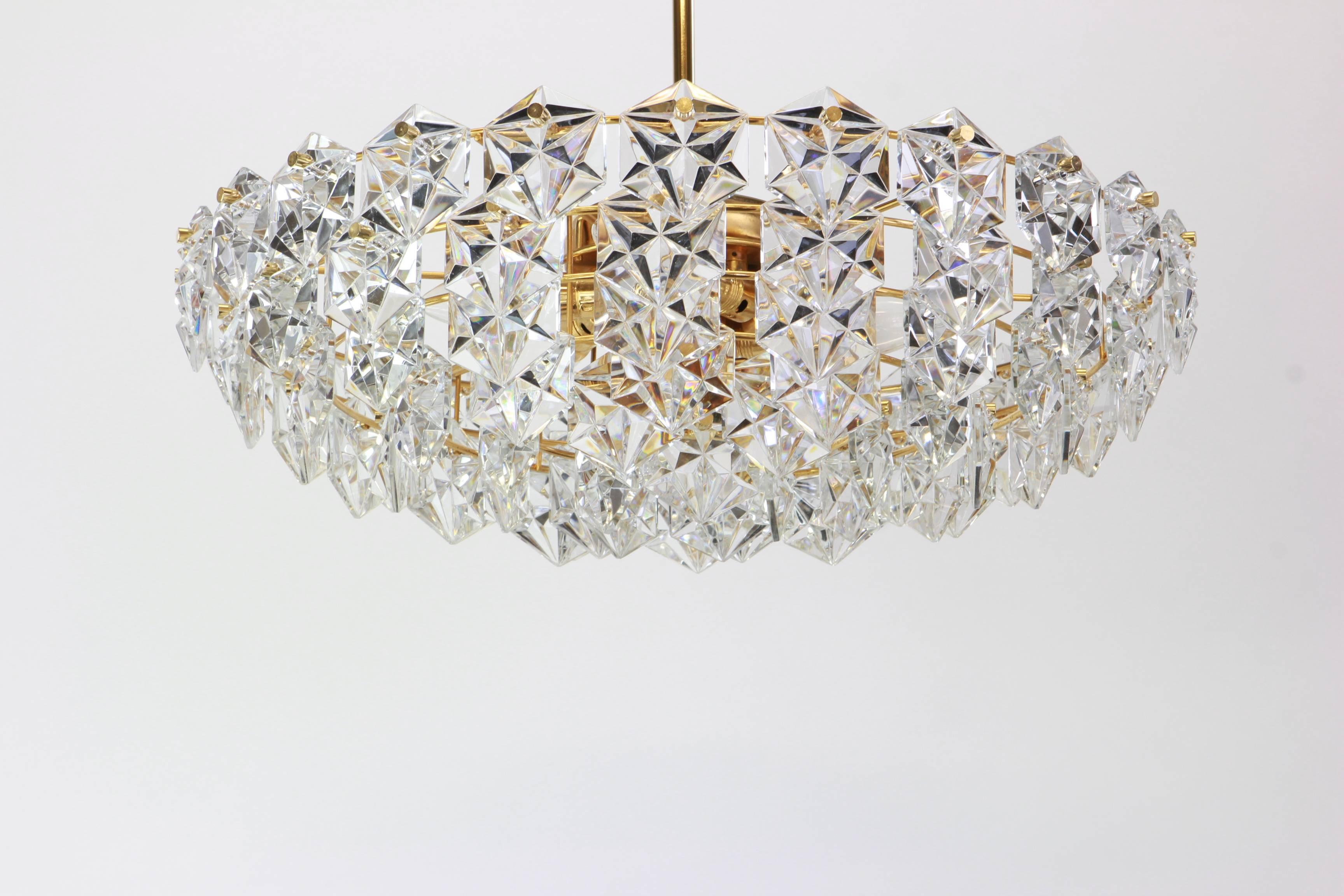 A stunning chandelier by Kinkeldey, Germany, manufactured in circa 1970-1979. A handmade and high quality piece. The ceiling fixture and the frame are made of brass and has rings with lots of facetted crystal glass elements.

High quality and in
