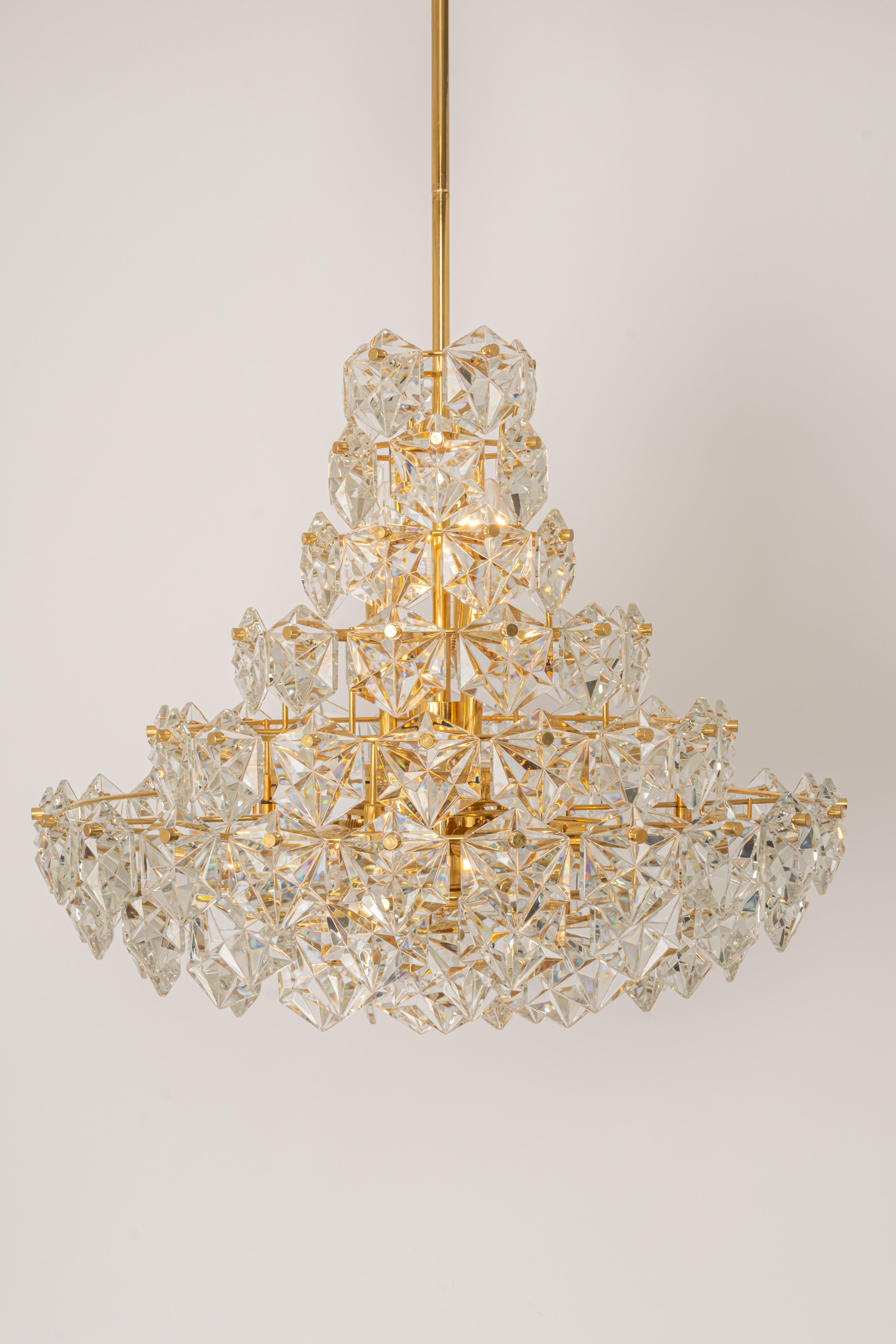 A stunning ten-tier chandelier by Kinkeldey, Germany, manufactured in circa 1970-1979. A handmade and high quality piece. The ceiling fixture and the frame are made of brass and has four rings with lots of facetted crystal glass elements.


High