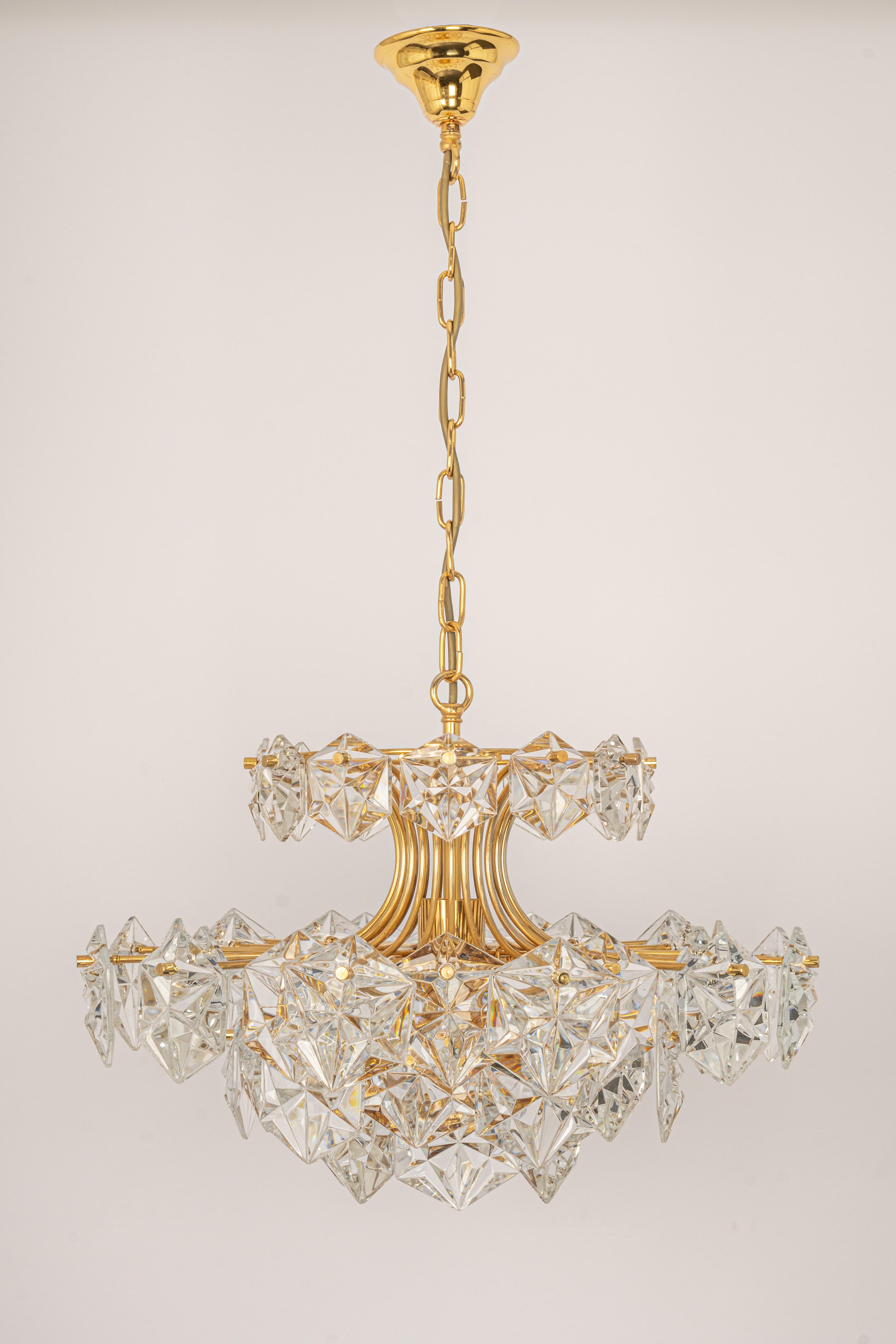 A stunning five-tier chandelier by Kinkeldey, Germany, was manufactured circa 1970-1979. A handmade and high-quality piece. The ceiling fixture and the frame are made of brass and have five rings with lots of facetted crystal glass