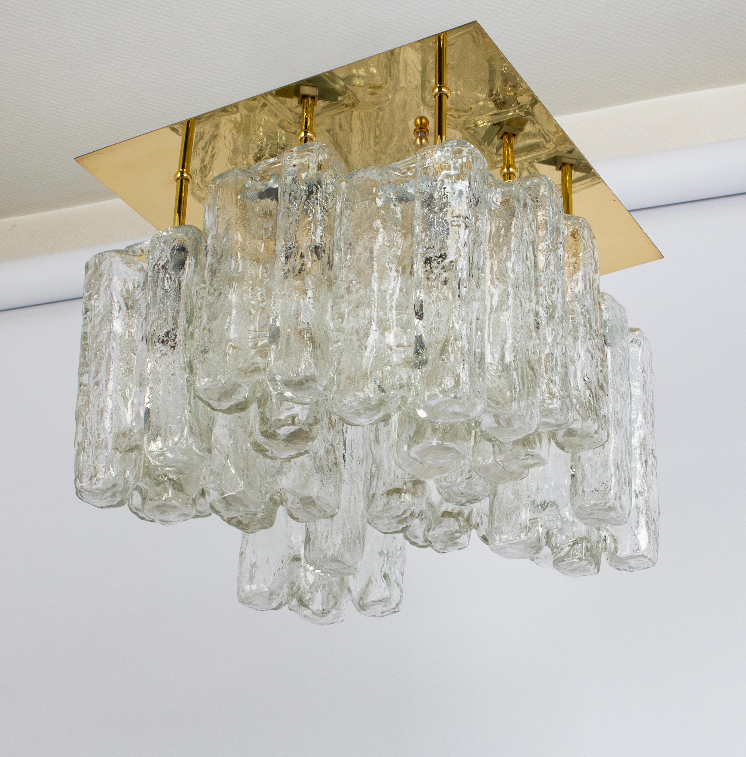 A stunning huge flush mount by Kalmar, Austria, manufactured in 1970s.
The flush mount is composed of 8 thick textured ice glass elements (Granadas) attached to a gold-brass frame.

The dimensions of each glass is: 4.5 x 4.5 x 9.5 inch // 11.5 x