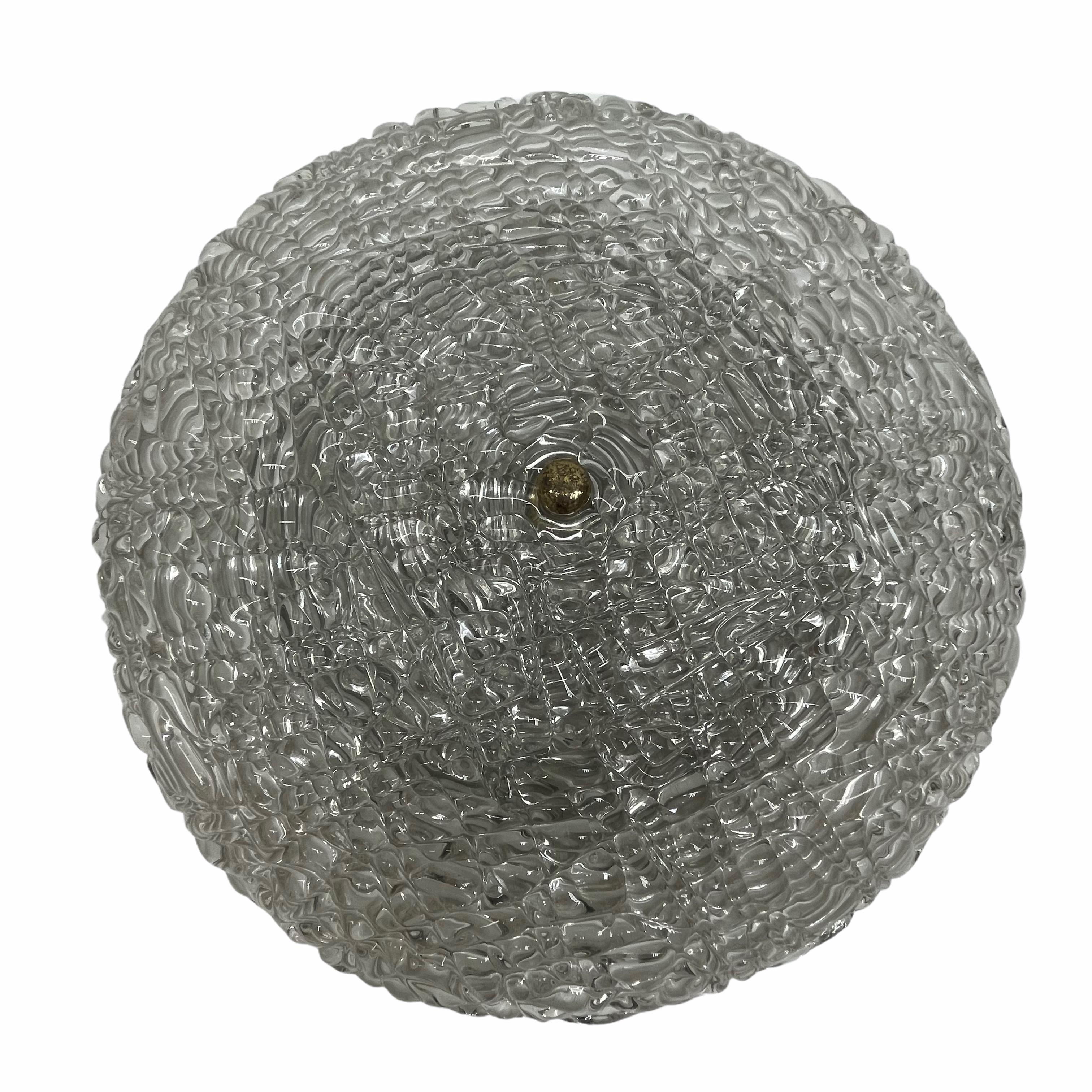 A stunning large textured clear glass flush mount by Kalmar Leuchten. It has a very heavy glass bowl on a metal frame. The Fixture requires three European E14 / 110 Volt Candelabra bulbs, each bulb up to 40 watts. Lightbulbs pictured are not