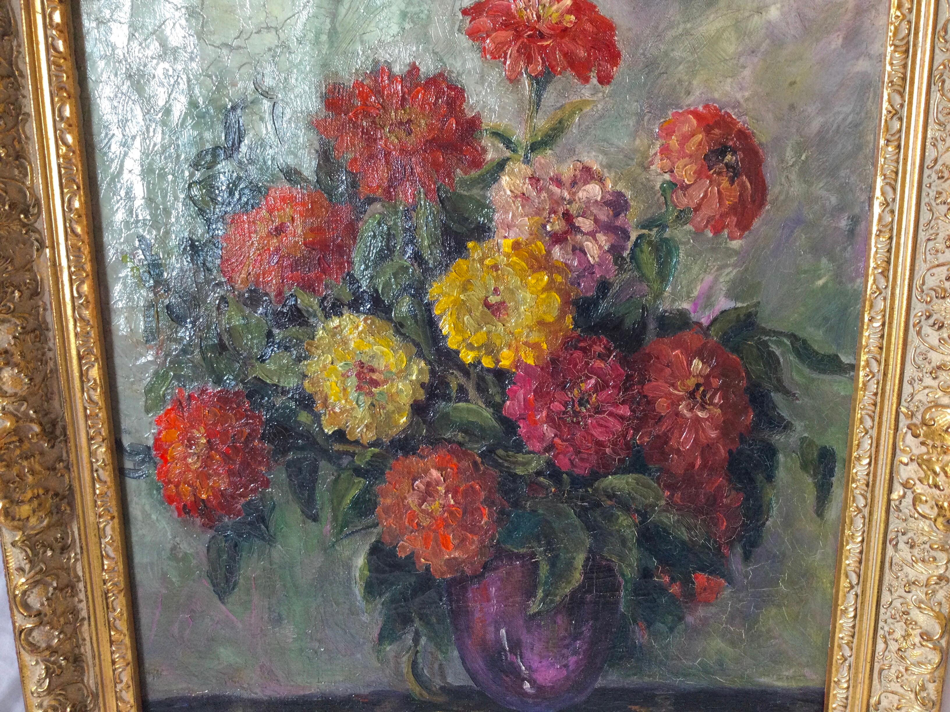 A beautiful oil painting on canvas of a bouquet of zinnias in a vase. The full bouquet with multicolored vibrant zinnias in an amethyst glass vase on a clothed table. Elegantly framed in a recent gilt wood frame. Circa 1920.