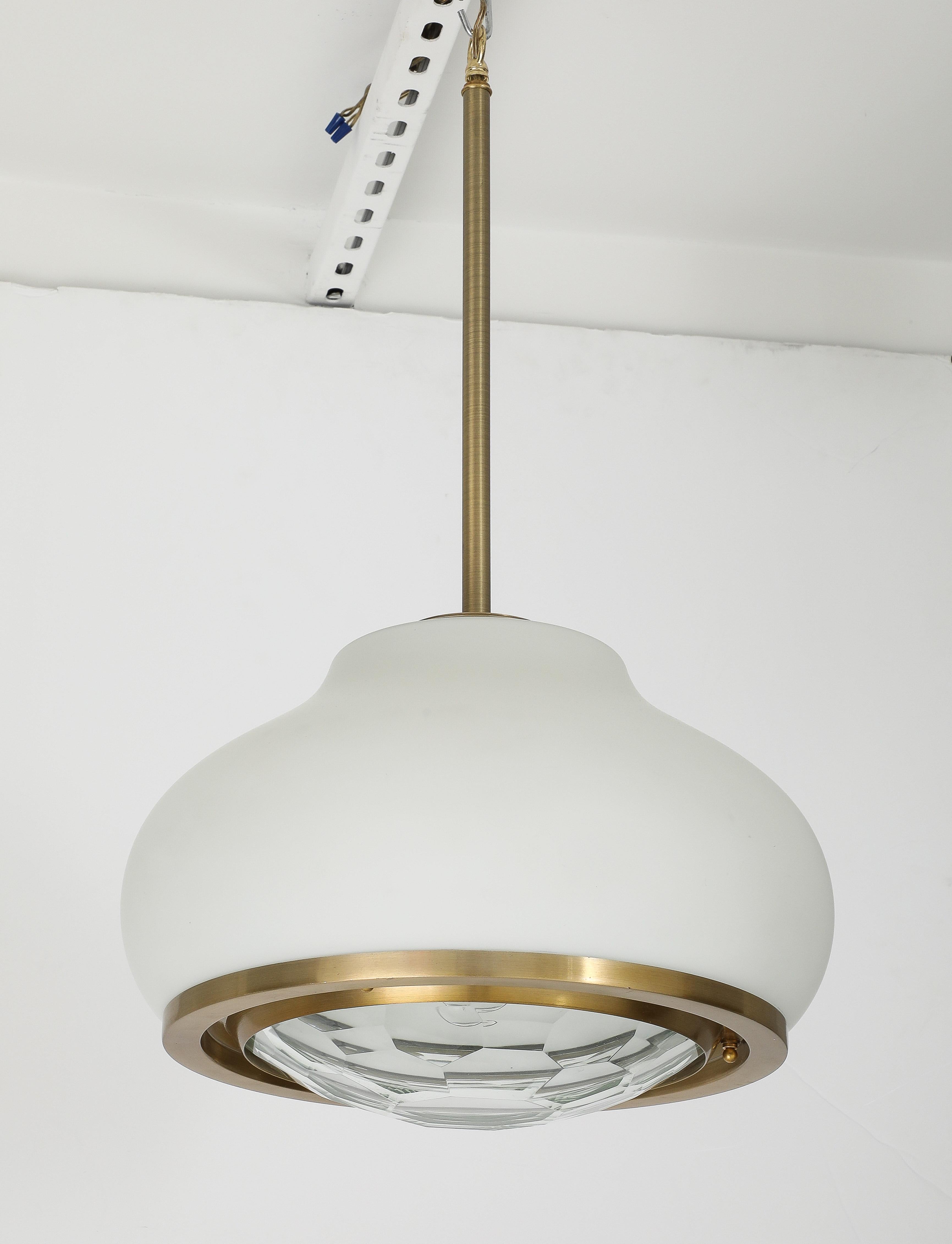 Large Italian opaque glass pendant light designed by Pia Guidetti Crippa.
The  bottom of the opaque glass body is trimmed with a satin brass disc which holds the beautifully convex Faceted dome which glistens when illuminated.
The light has been