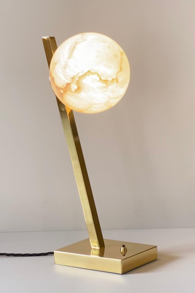 The Offset table lamp is a stunning piece that exudes elegance and sophistication. The backlighting of the veined alabaster creates a magical and ethereal effect, reminiscent of a full moon on a summer night. The use of natural materials, such as