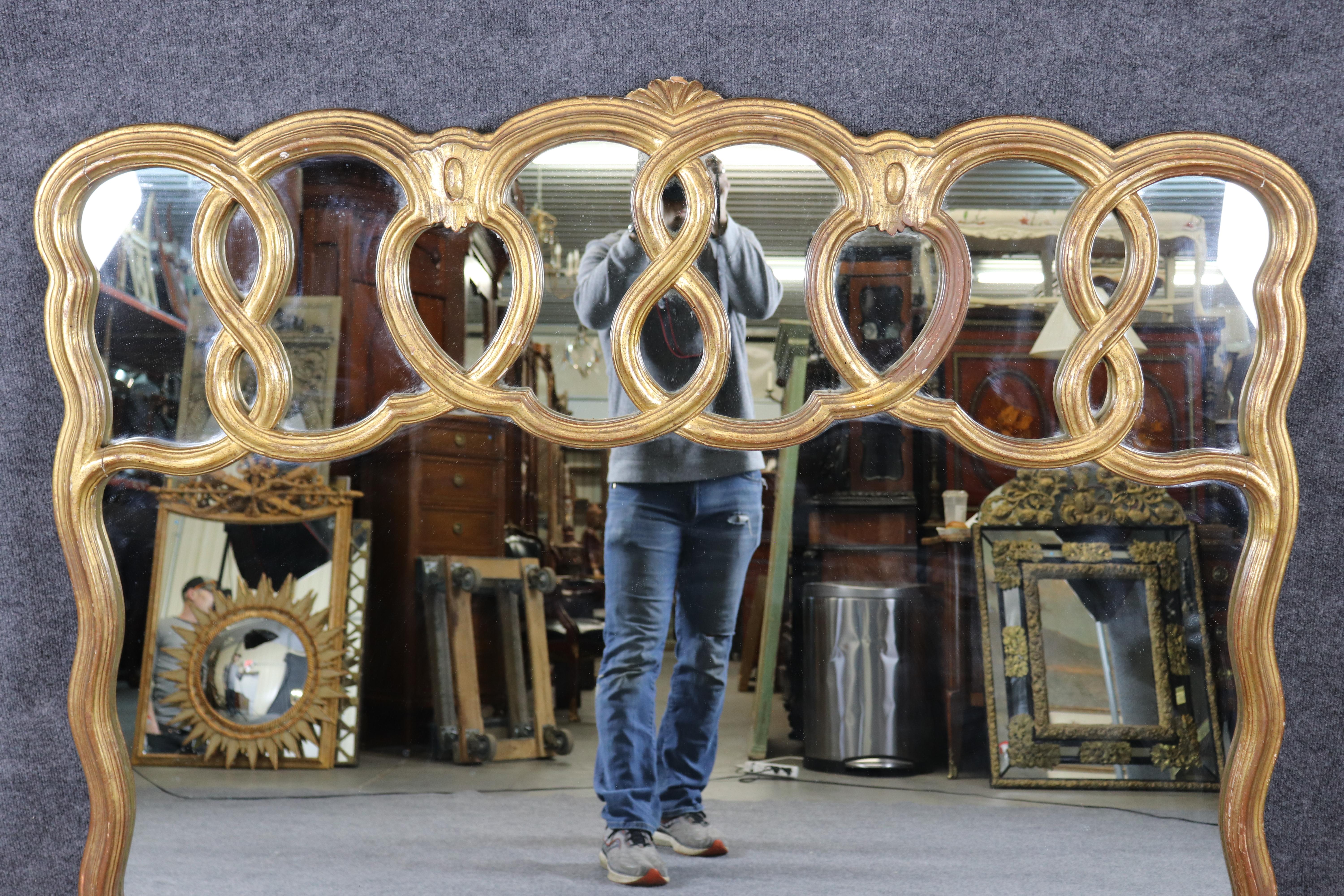 Il s'agit d'un miroir remarquable, au design unique et sophistiqué, que l'on voit rarement. Le cadre est magnifiquement doré à la feuille d'or véritable et magnifiquement patiné par le temps et le polissage. Le miroir est grand et parfait pour un