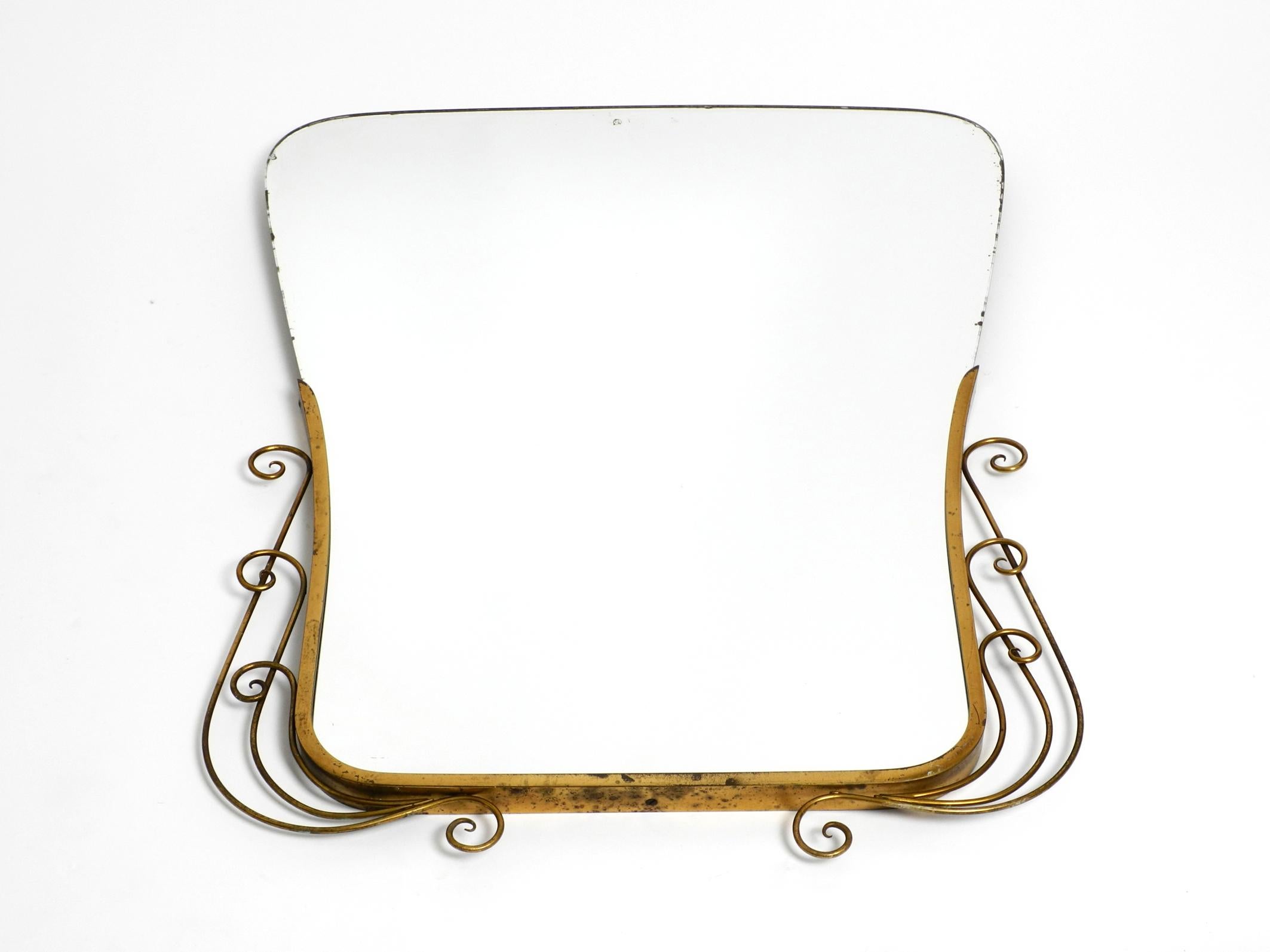 Exceptionally beautiful Italian mid century wall mirror.
Great elaborate design with ornate brass frame in diabolo shape.
Very good vintage condition without damage with a wonderful patina on the brass.
No damage to the entire mirror. Glass
