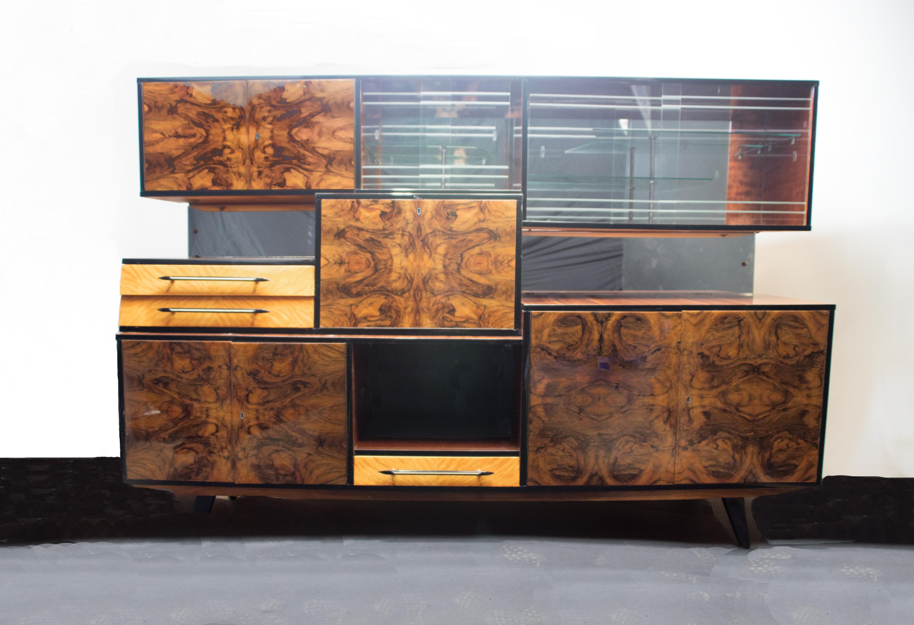 Large Italian wall unit, dry bar, storage cabinet attributed to Osvaldo Borsani, Stunning book match, exotic burl wood featuring 3 locking storage cubbies, center light up drop down bar with mirror back and surface.3 drawers, 2 display cabinets with