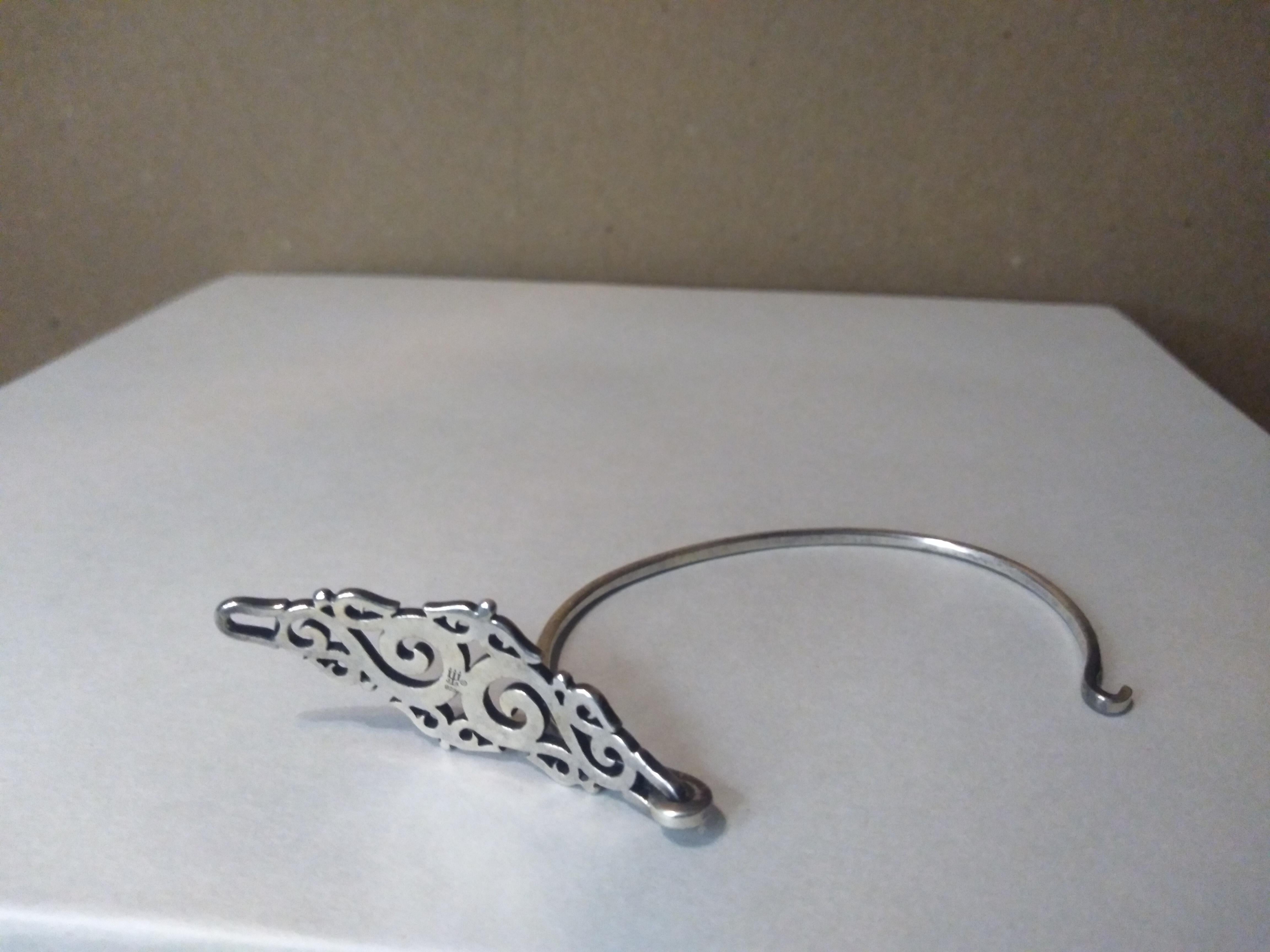 This is a beautiful James Avery bracelet. It's made of sterling silver and has a filligree face. The band is solid sterling and it has a hook clasp.