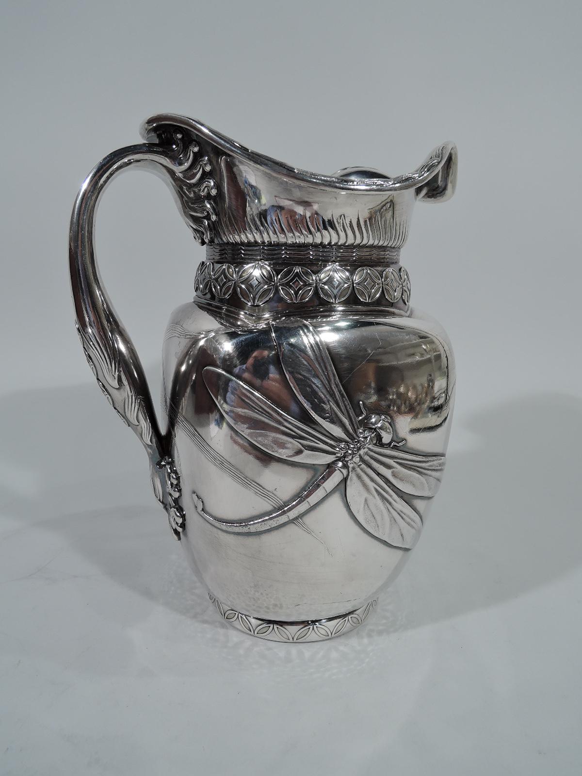 Japonesque sterling silver water pitcher. Made by Whiting in New York, circa 1885. Four curved sides, short round neck, wavy asymmetrical mouth, and scrolled handle. Applied bold spillover ornament. On one side is a dragonfly with wings and tail