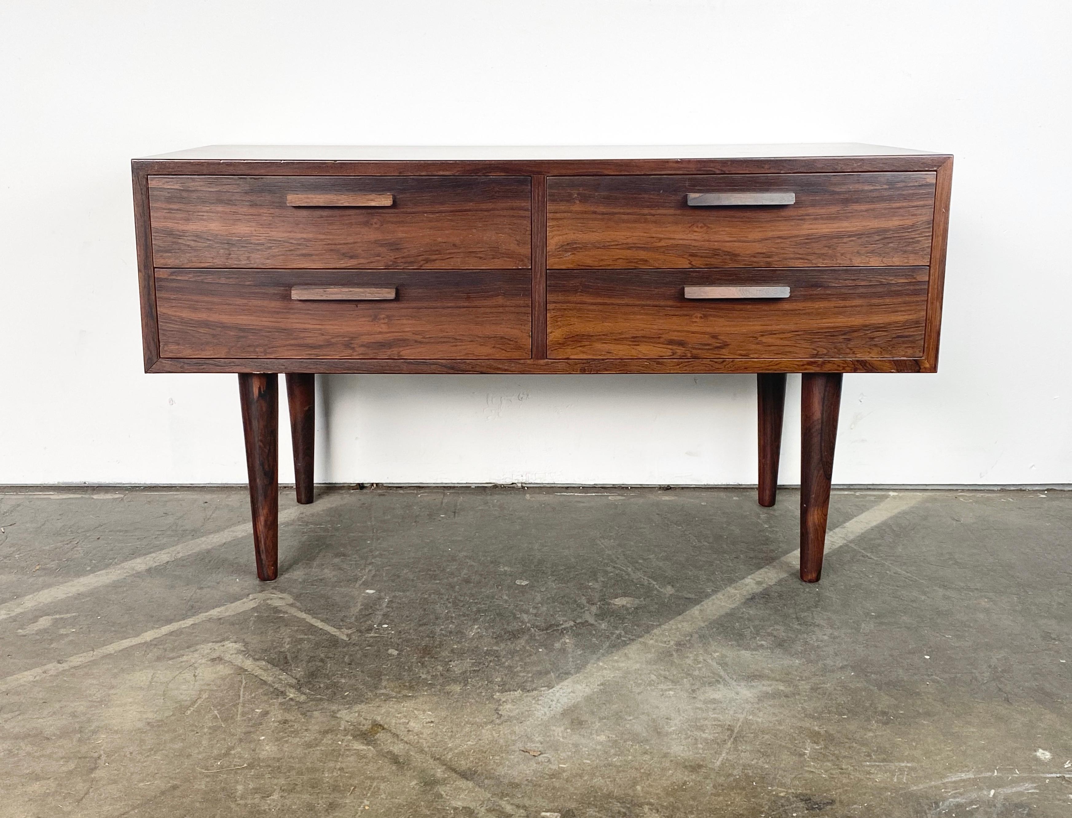 Stunning small dresser by Kai Kristiansen. Finished in luxurious Brazil rossewood with exceptional grain detail and contrast. Dovetailed drawers open smoothly. Legs in great shape. Overall a fabulous piece exhibiting only minimal wear commensurate