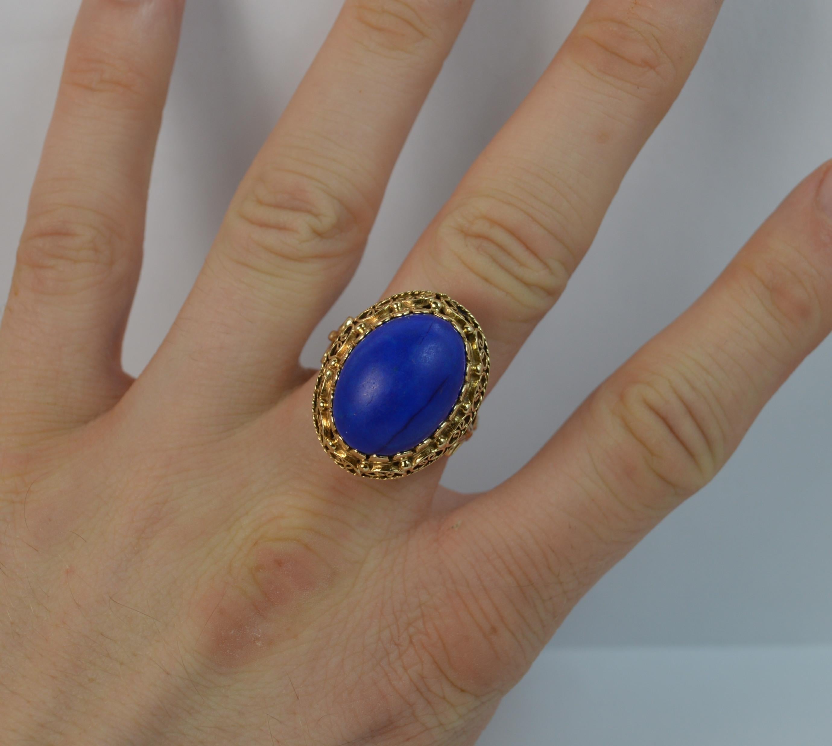 A highly unusual ladies ring. Solid 14 carat yellow gold example. 
SIZE ; O 1/2 UK, 7 1/2 US
A large lapis lazuli stone of oval shape, 14mm x 18mm. Protruding 15mm off the finger.

The stone is in a pierced head setting with braided design to the