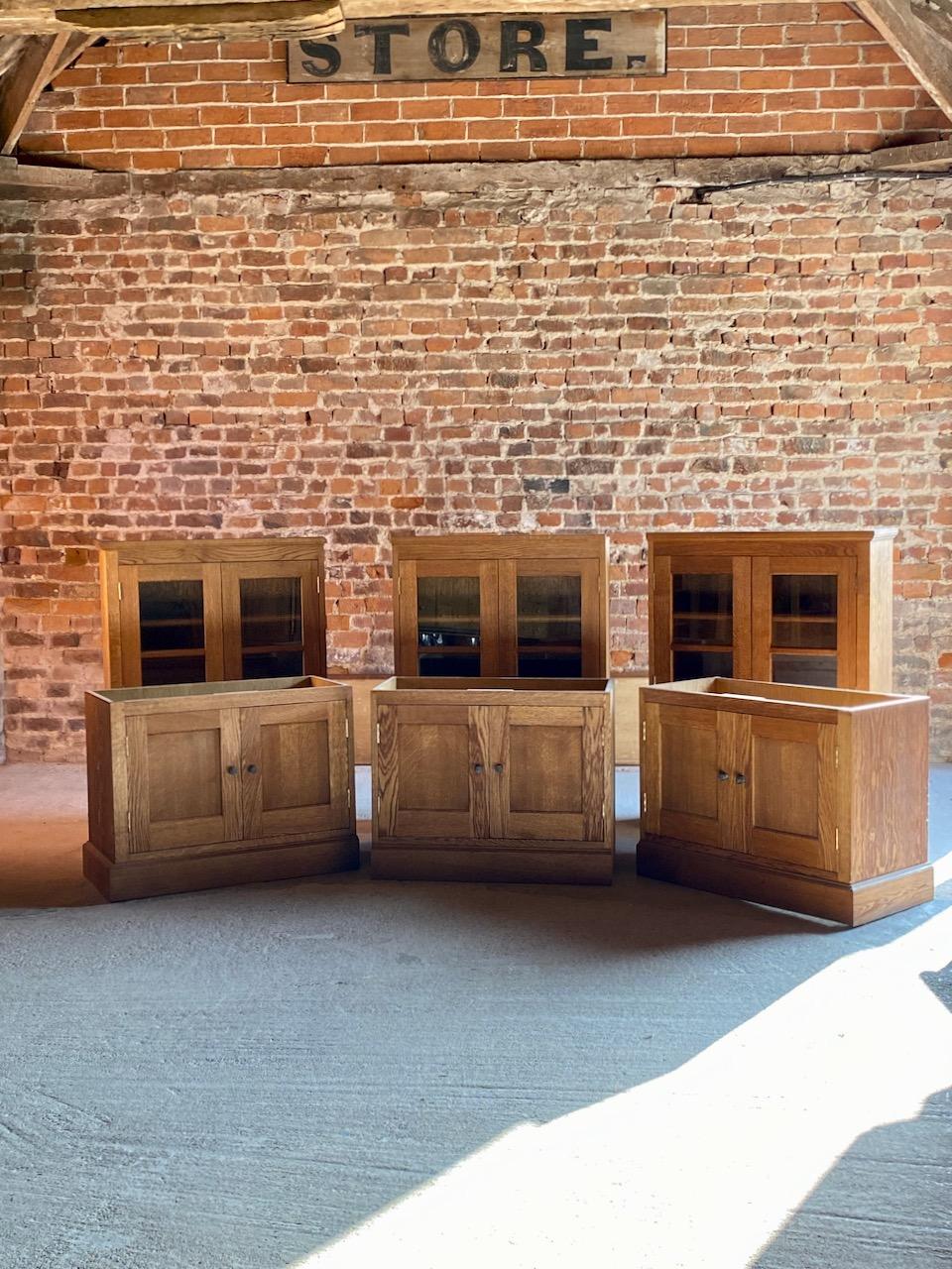 Stunning large and imposing 20th century apothecary display cabinet or bookcase in solid English light oak, 20th century, the upper section with six glazed paneled cabinet doors each with four adjustable shelves, over six paneled cupboard doors,