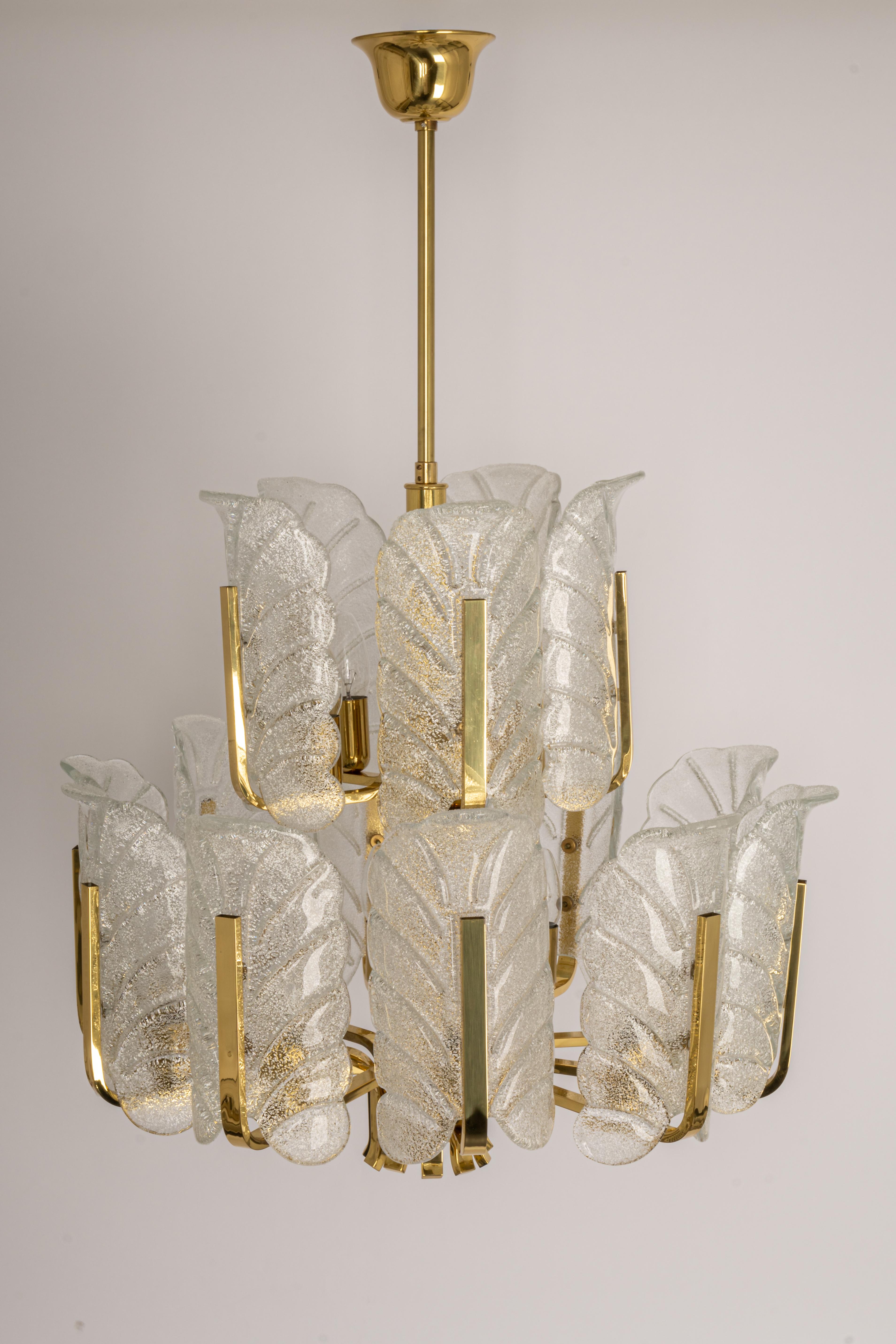 Very glamorous chandelier designed by Carl Fagerlund for Orrefors glass, Sweden, manufactured in midcentury, circa 1960-1969. The light features a polished brass frame with 15 stunning Murano glass leaves which have a matte frosted relief on the
