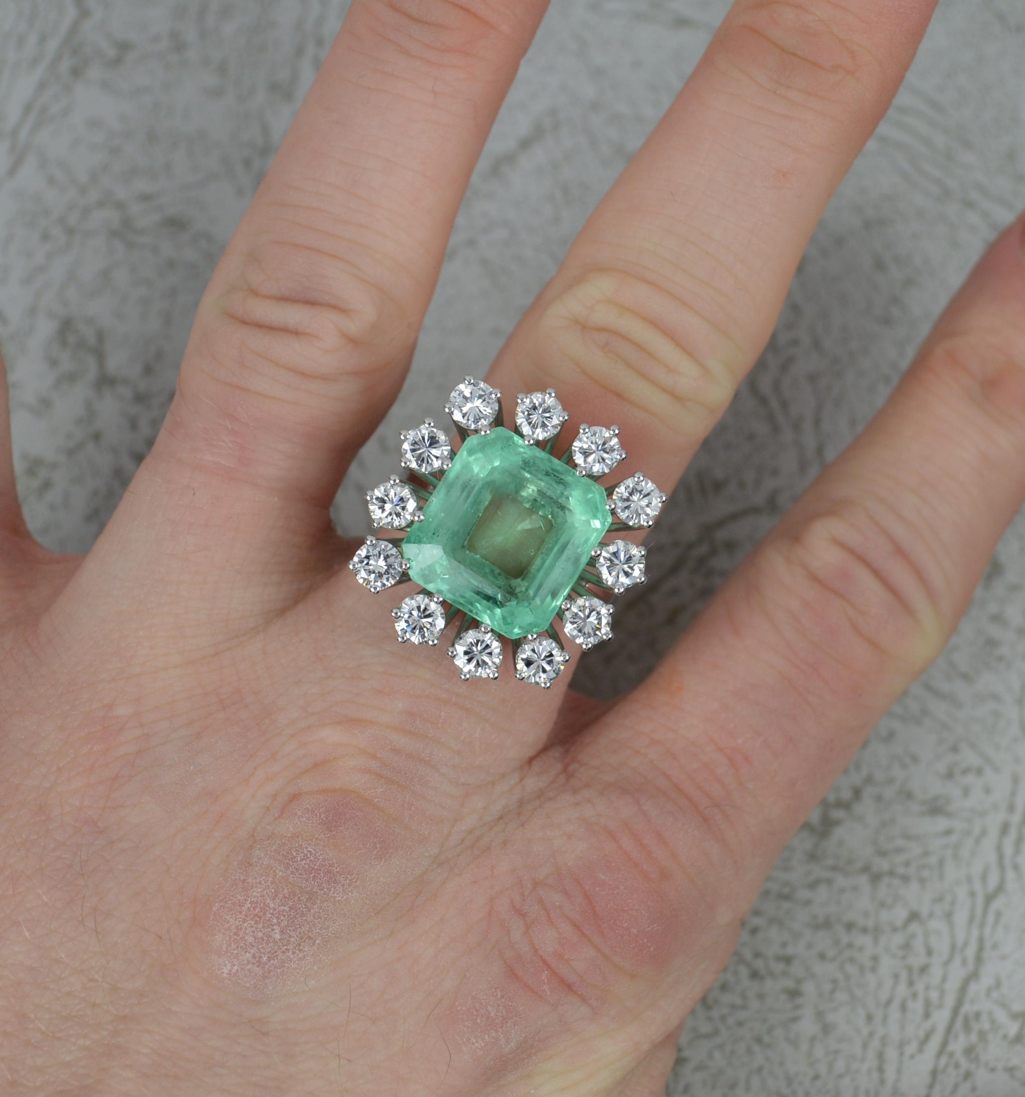 A stunning and large Emerald and Diamond cocktail ring.
Solid 18 carat white gold example.
Set with a large emerald cut emerald to centre, 12.8mm x 13.6mm x 7.5mm approx. Very clean and bright emerald. Minor inclusions only.
Surrounding are twelve