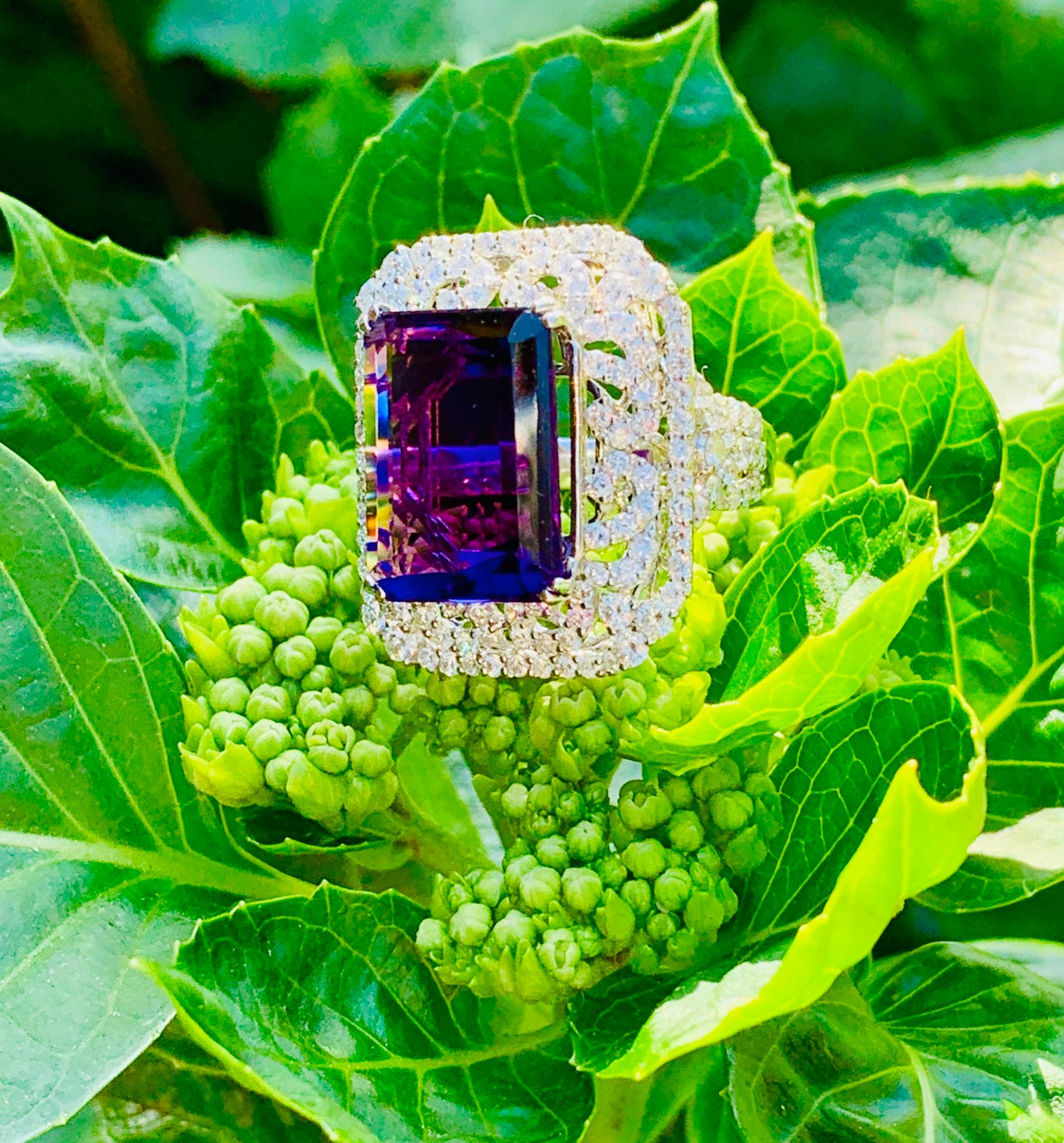 Magnificent 11 carat rectangular step-cut or emerald cut, deep purple Siberian amethyst is talon prong set above a dazzling 3 carat, curlicue pattern of pave set round brilliant white diamonds, finished with a micro pave halo and diamond shoulders