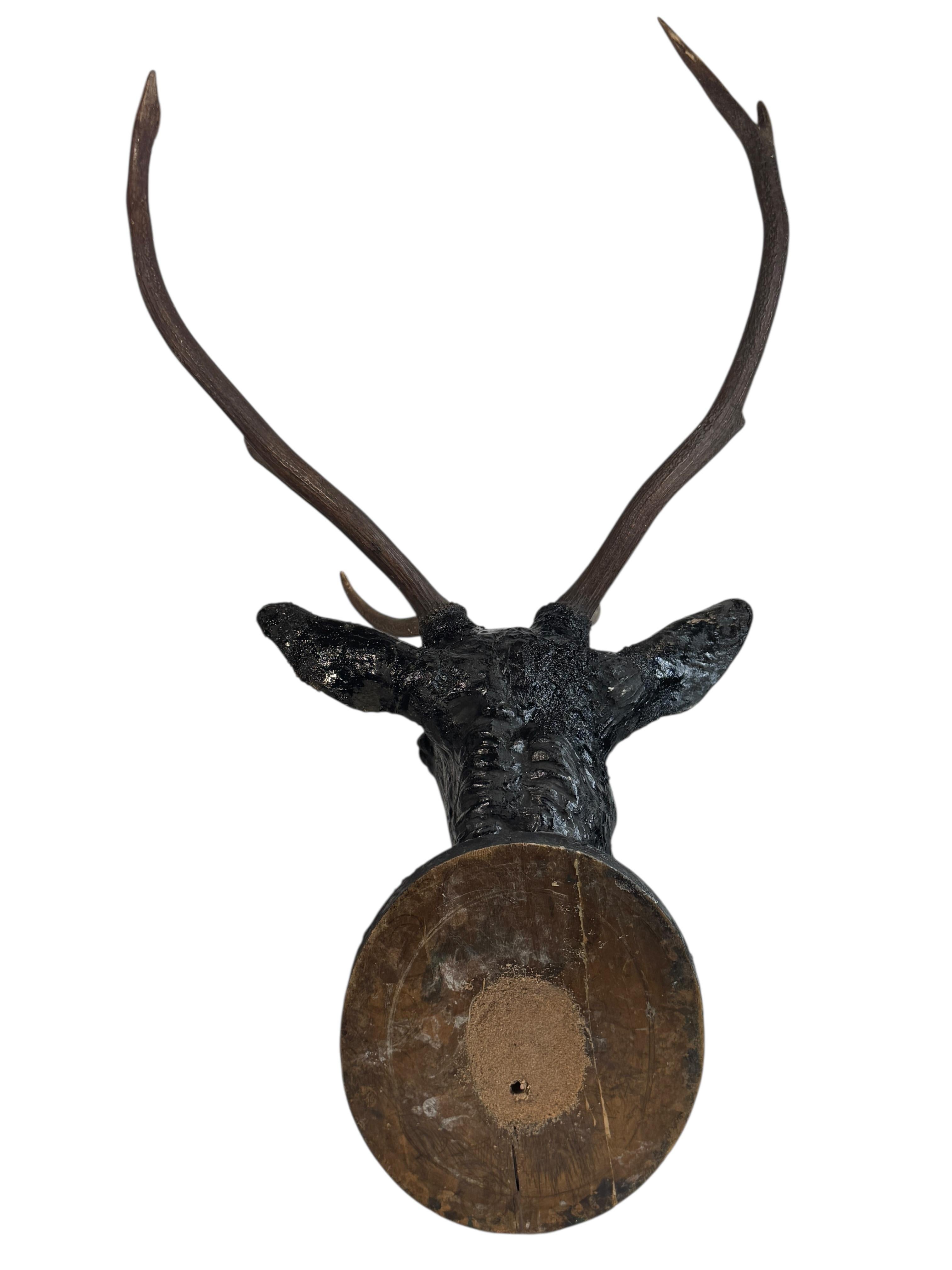 Une superbe décoration murale en bois sculptée à la main, de style Folk Art, avec une tête de cerf. Une pièce idéale pour créer une ambiance appropriée dans une salle de trophées ou le bureau d'un chasseur ou d'un bûcheron. Il s'agit très