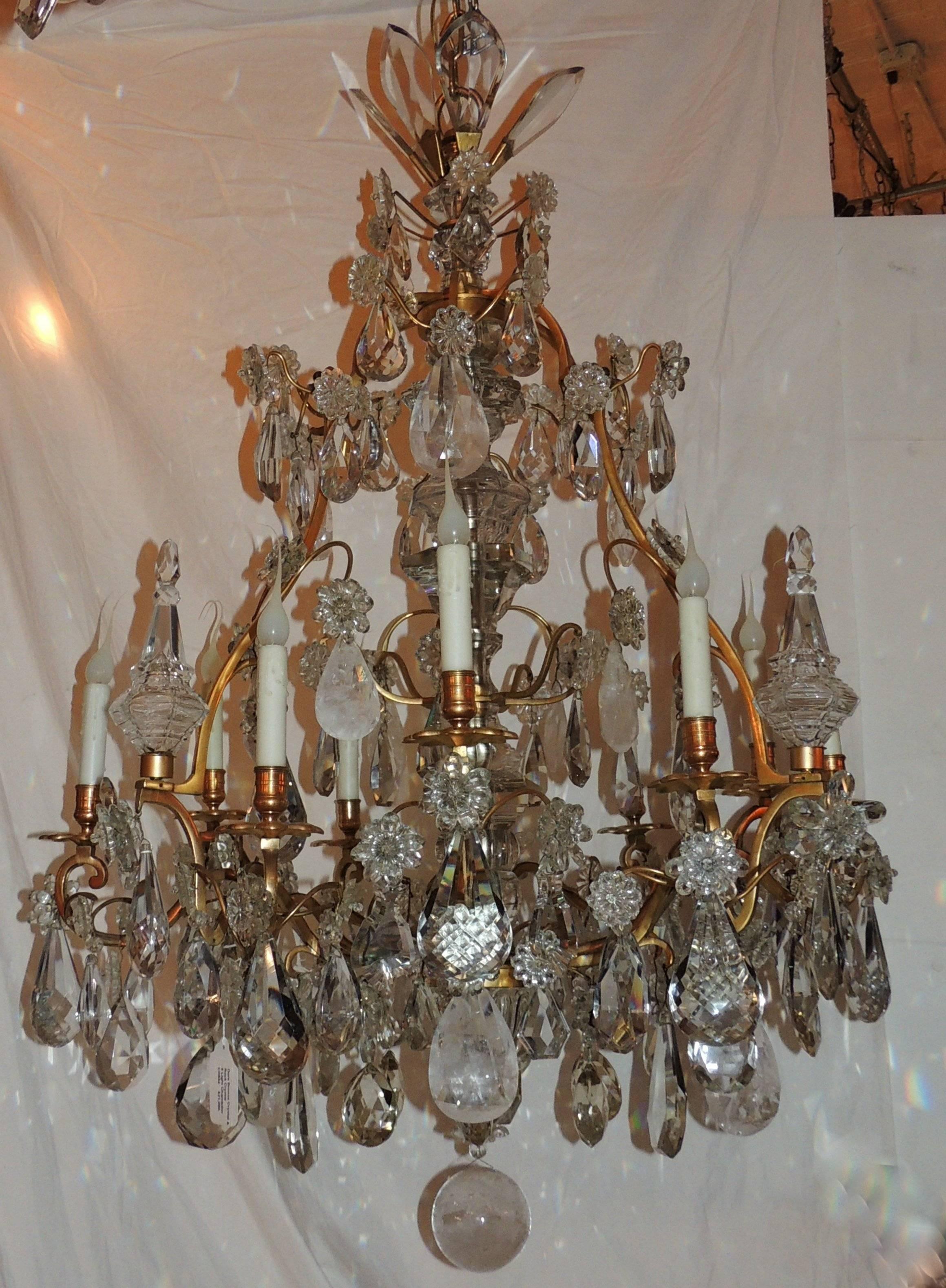 This beautiful nine-light chandelier is layered with wonderful scrolling doré bronze arms, multifaceted and textured crystal pendants and highlighted by rock crystal pendants and crystal obelisk, French.

Measures: 52
